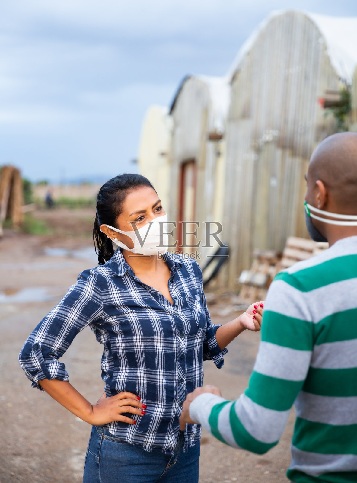 几个带着医用口罩的园丁在农场后院聊天照片摄影图片
