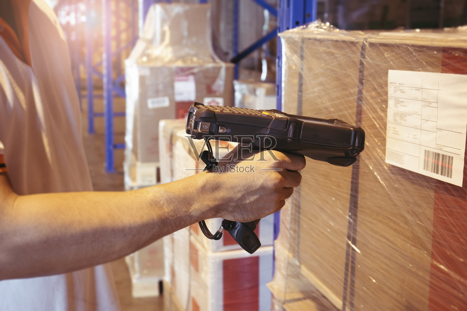 工作人员用条码扫描仪扫描商品标签。用于仓库库存管理的计算机设备。照片摄影图片