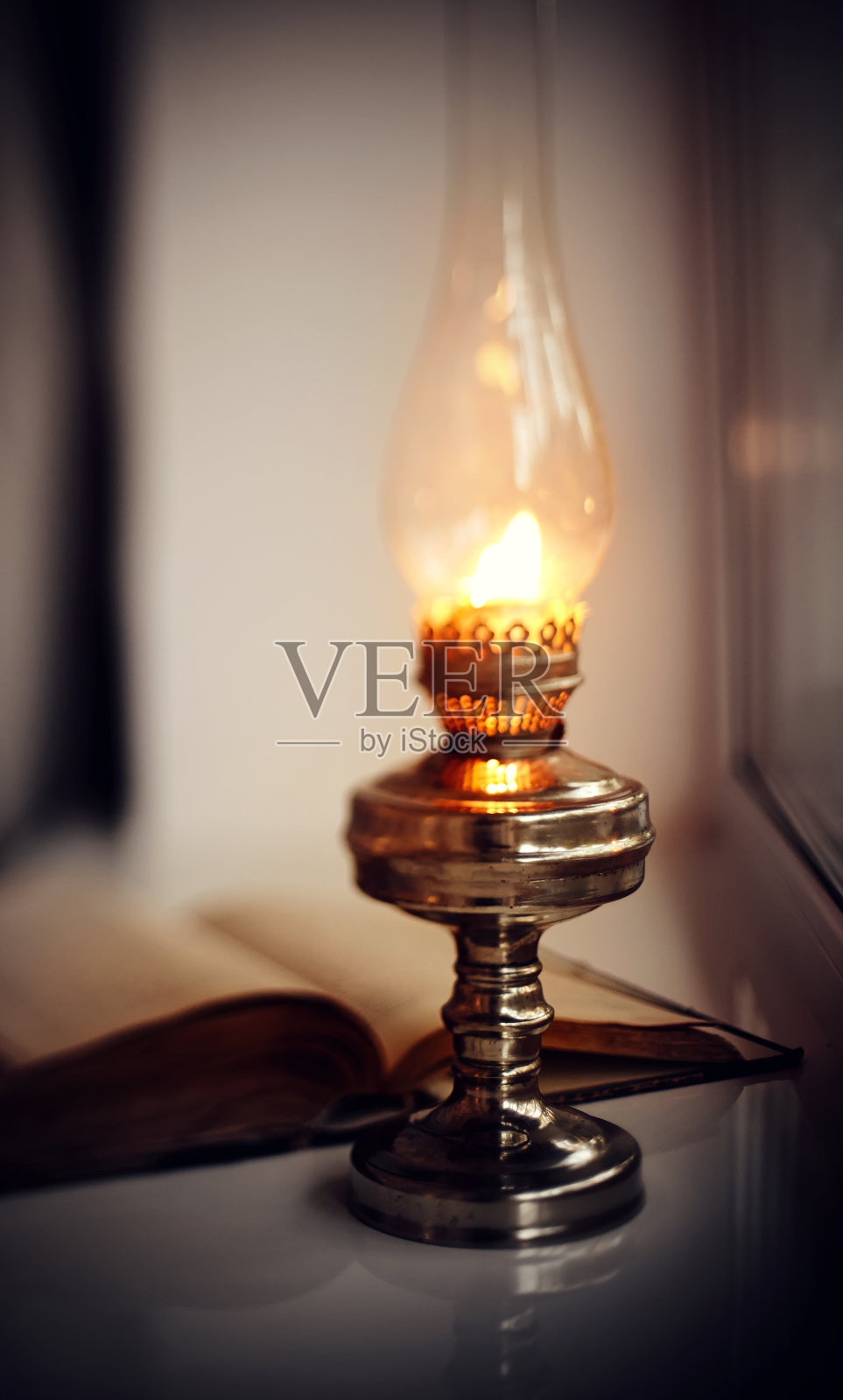 老式的煤油灯和老式的打开的书。照片摄影图片