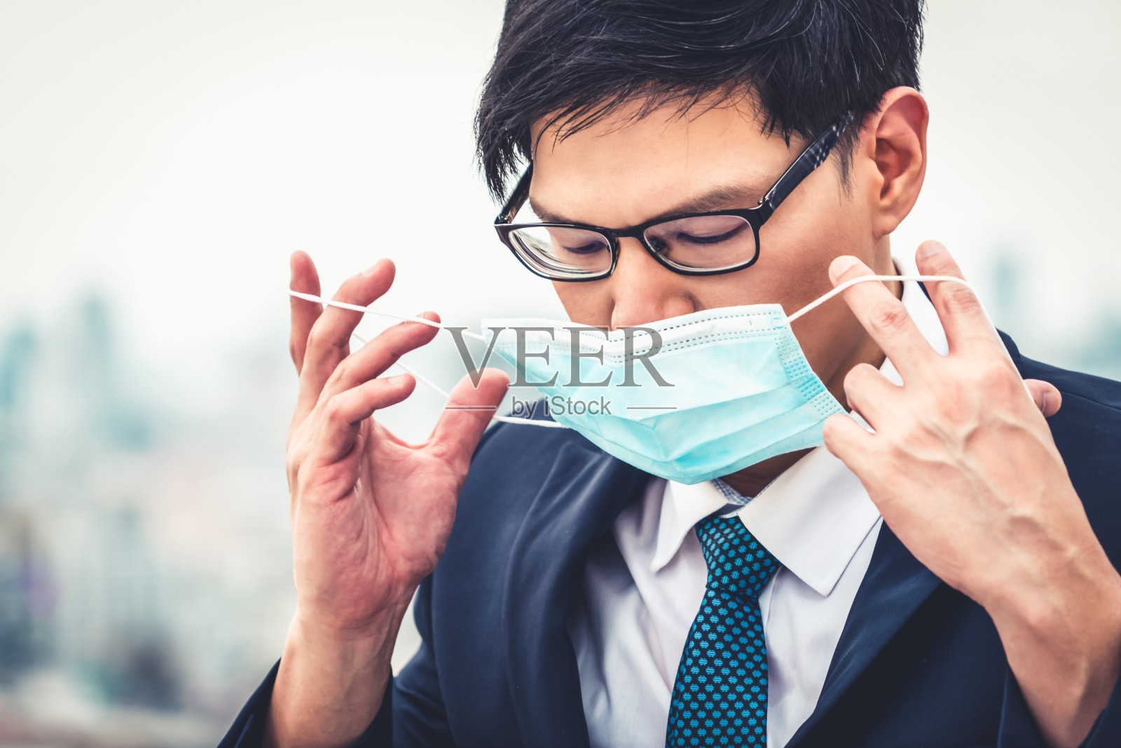 年轻白领戴口罩，与冠状病毒或COVID-19隔离。照片摄影图片