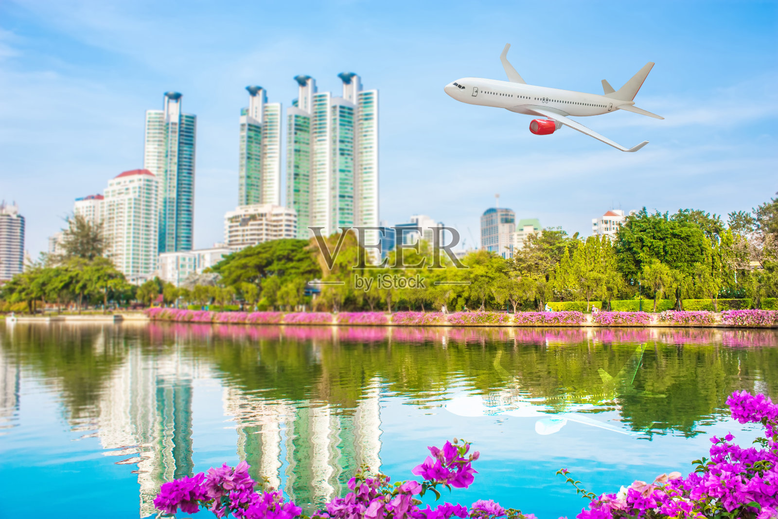 飞机飞过摩天大楼的城市，交通概念。照片摄影图片