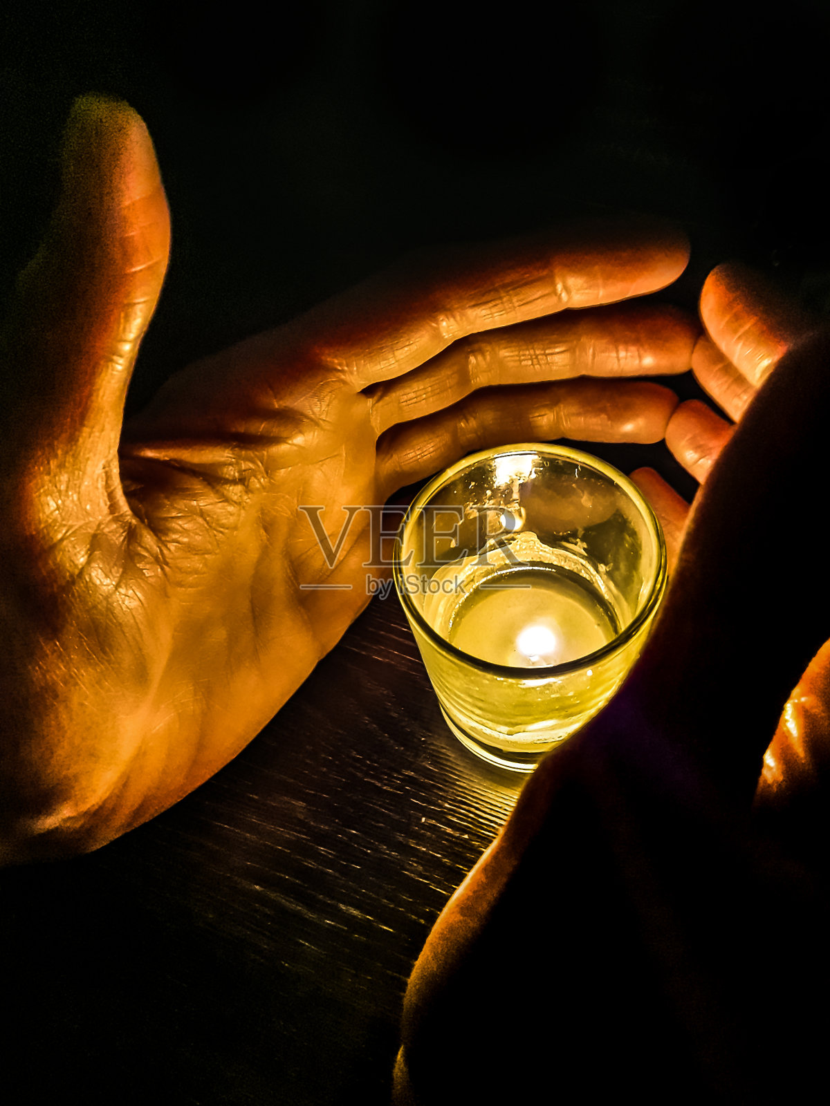 用手遮住玻璃上的蜡烛照片摄影图片