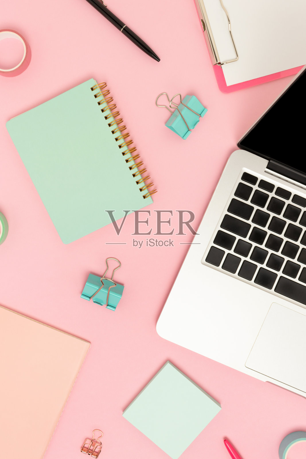 在粉红色背景上的笔记本和文具俯视图。照片摄影图片