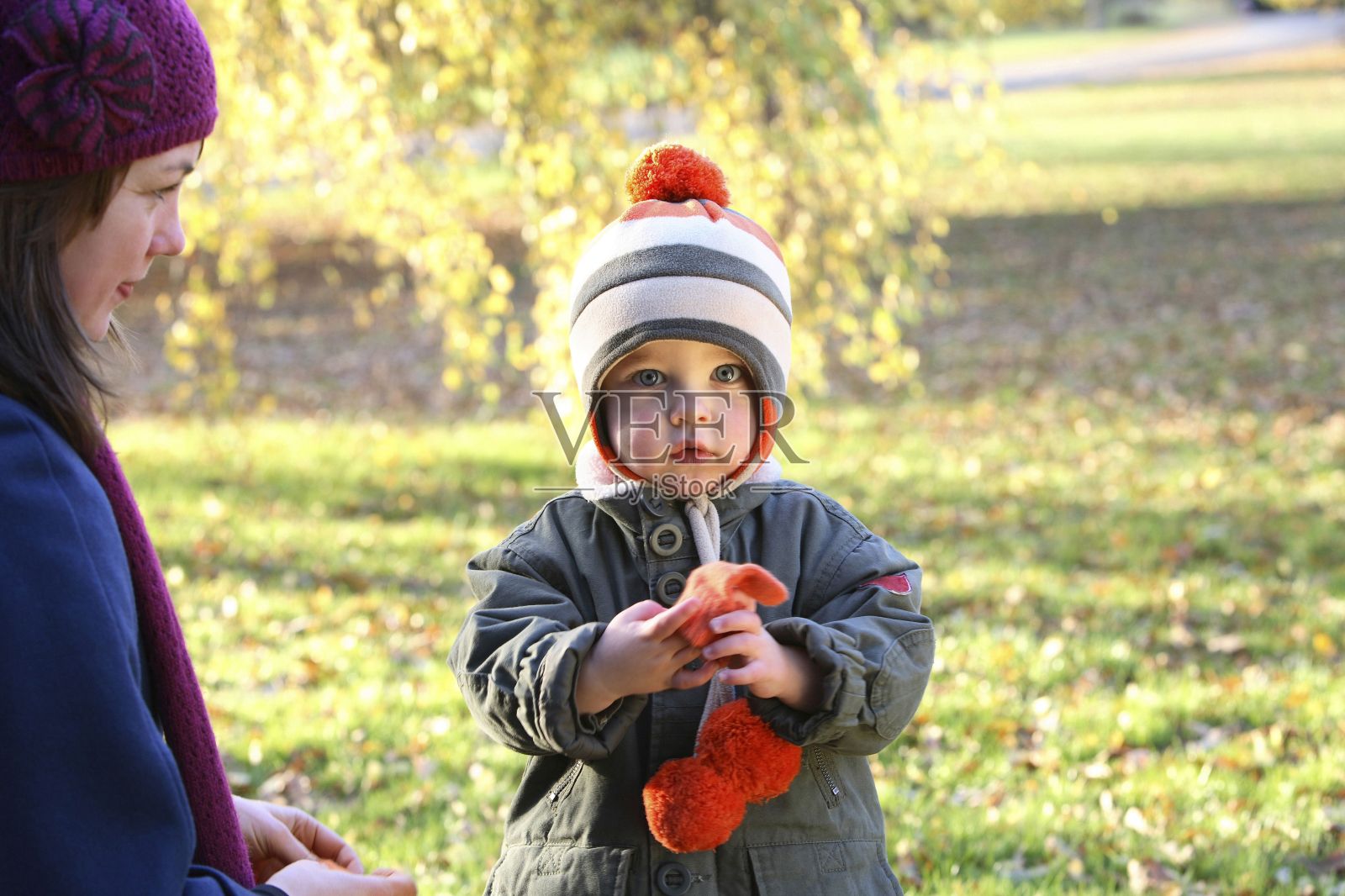 妈妈看着拿着手套的儿子看着摄像机照片摄影图片