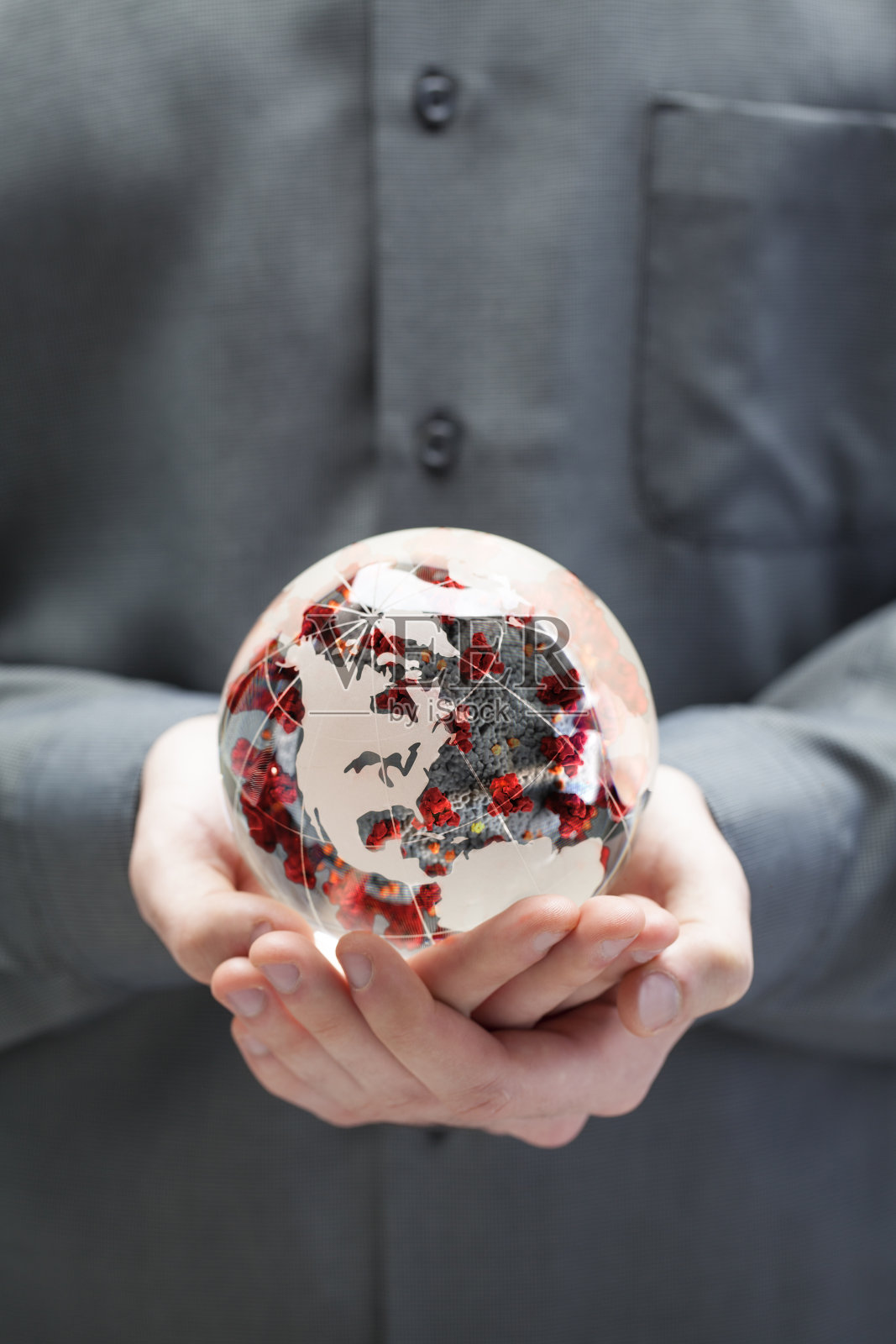 手持嵌在玻璃球中的covid-19冠状病毒的男子照片摄影图片