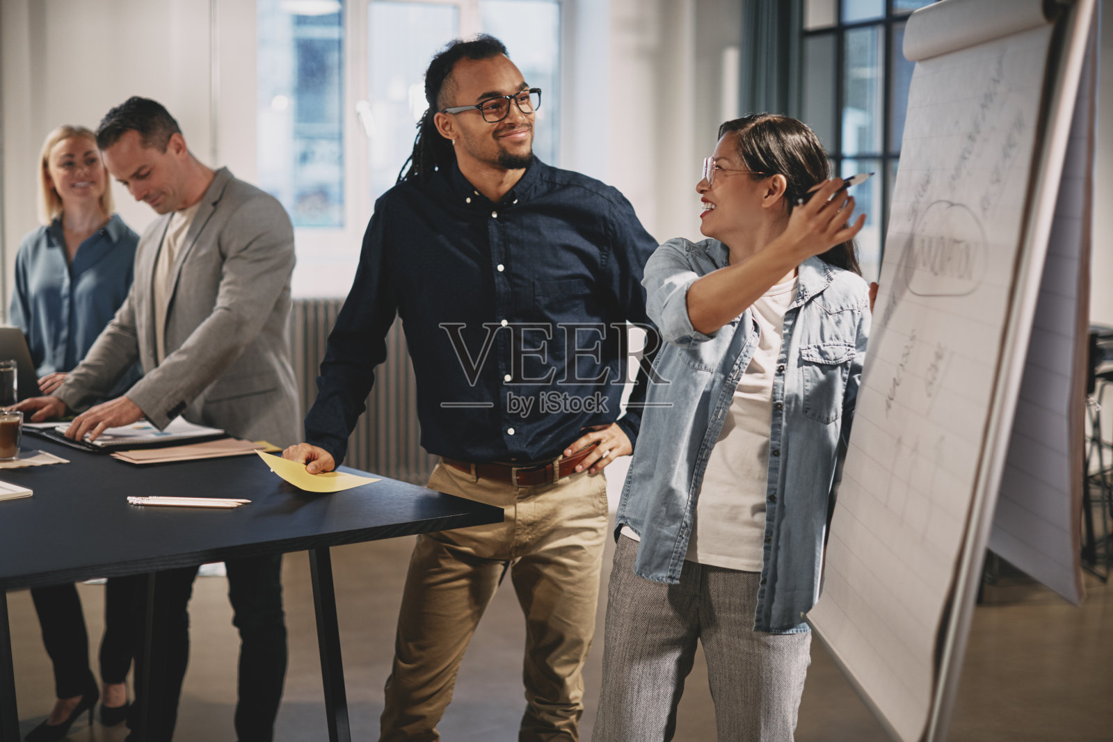 微笑的商务人士在办公室里一起交谈照片摄影图片