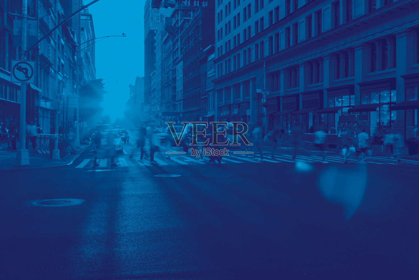 在纽约曼哈顿，一群人穿过一个繁忙的十字路口，彩色的蓝色效果照片摄影图片