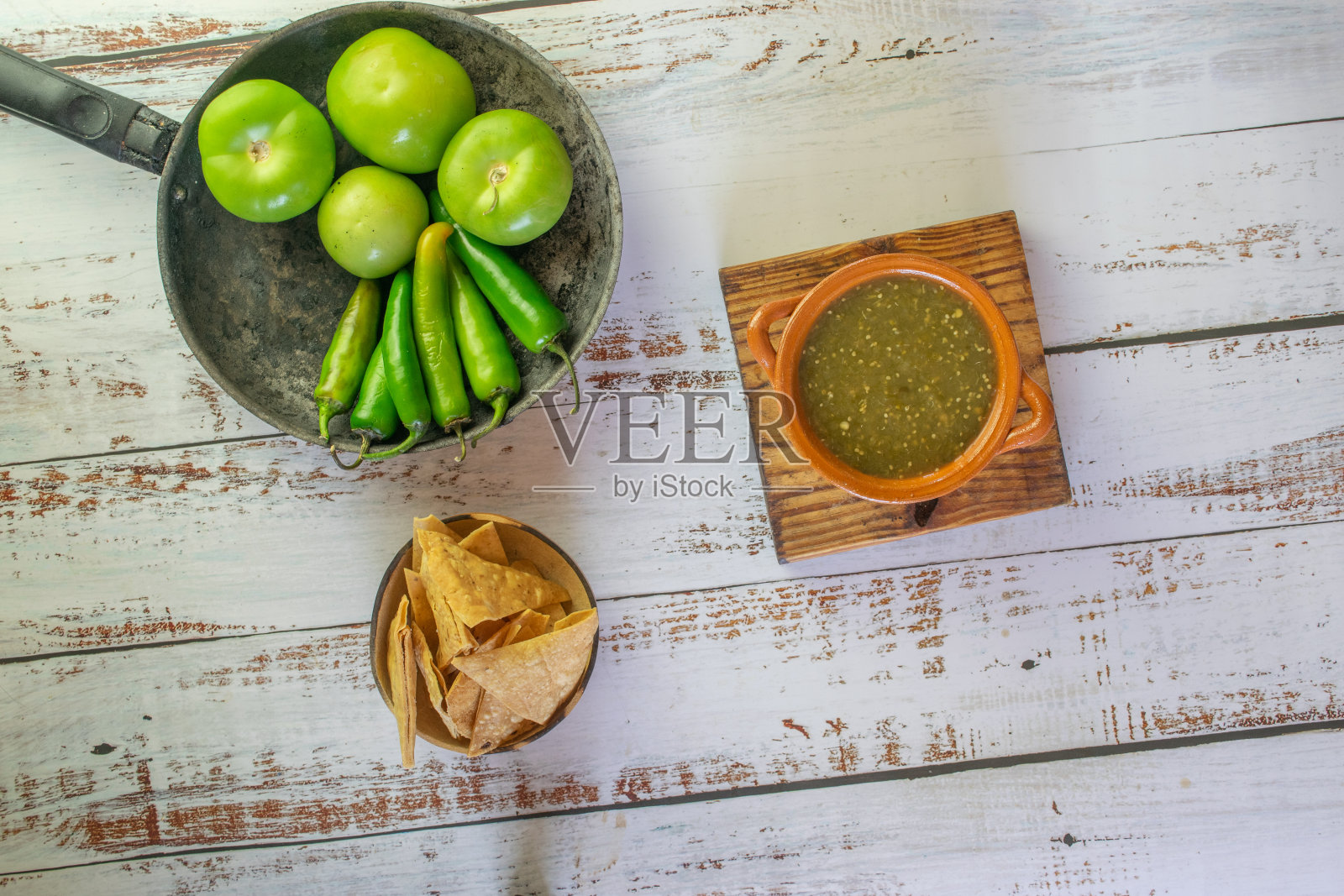 俯视图墨西哥绿酱与玉米片，番茄和塞拉诺辣椒照片摄影图片