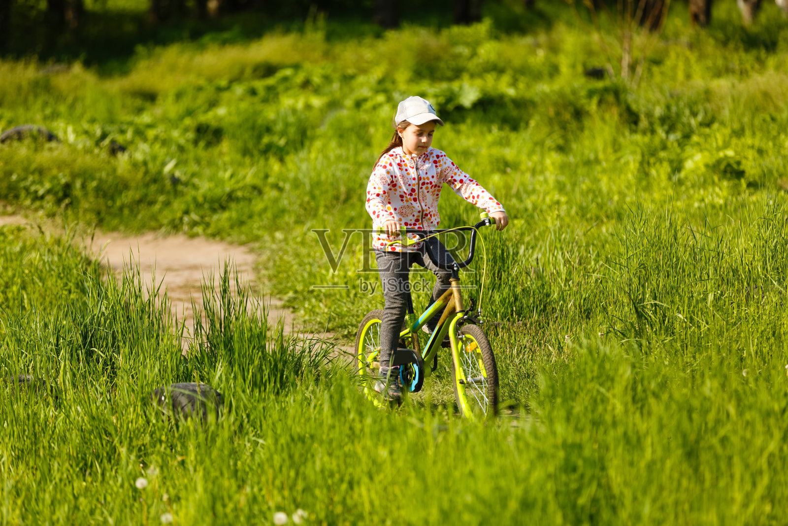 一个小女孩在夏天的公园户外骑自行车的肖像照片摄影图片