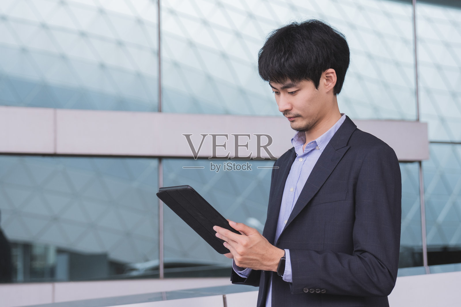 商人站在办公室里使用平板电脑照片摄影图片