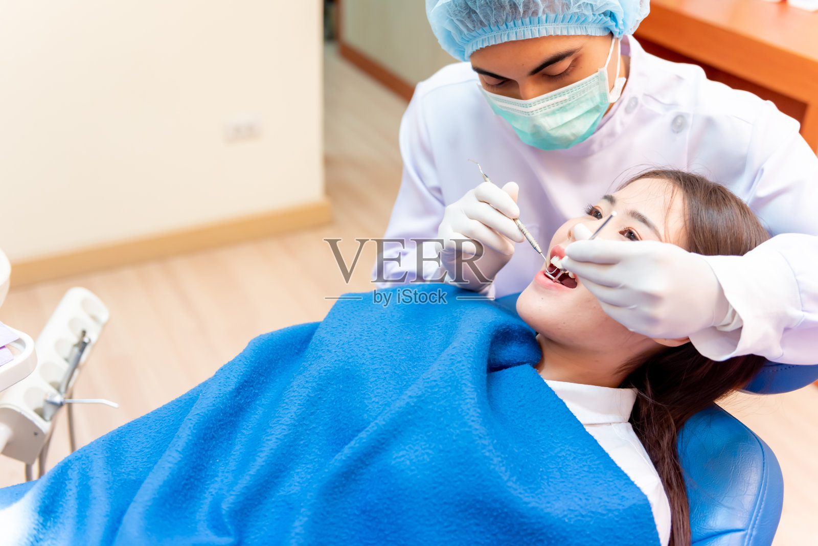 牙科和牙齿保健。牙医为亚洲病人检查牙齿。在牙科诊所工作的医生和生活方式。照片摄影图片