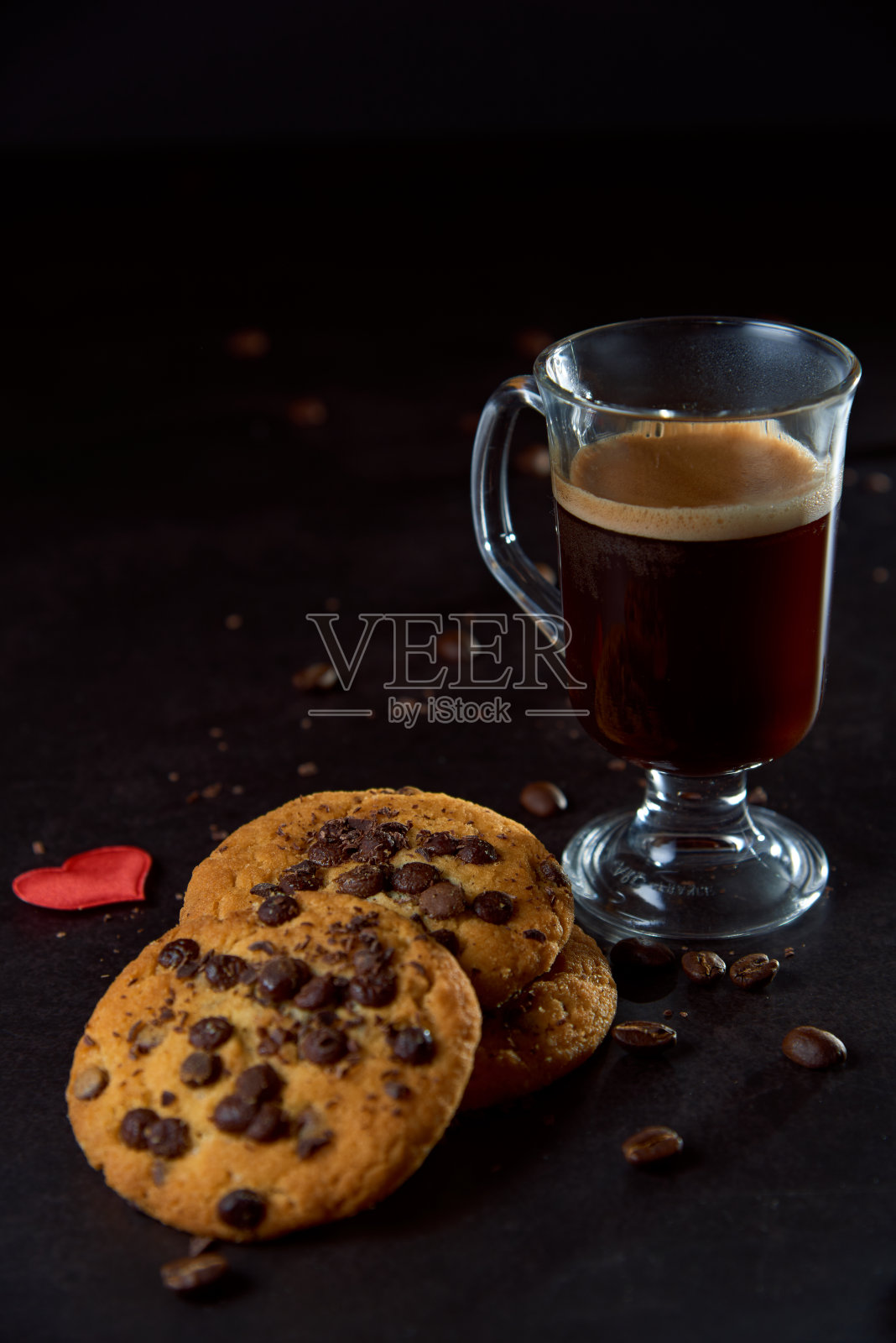 近距离的一杯咖啡，巧克力饼干和roastedÂ coffeeÂ豆在黑暗的背景。概念即食食品，美味小吃。选择性聚焦，复制空间。照片摄影图片