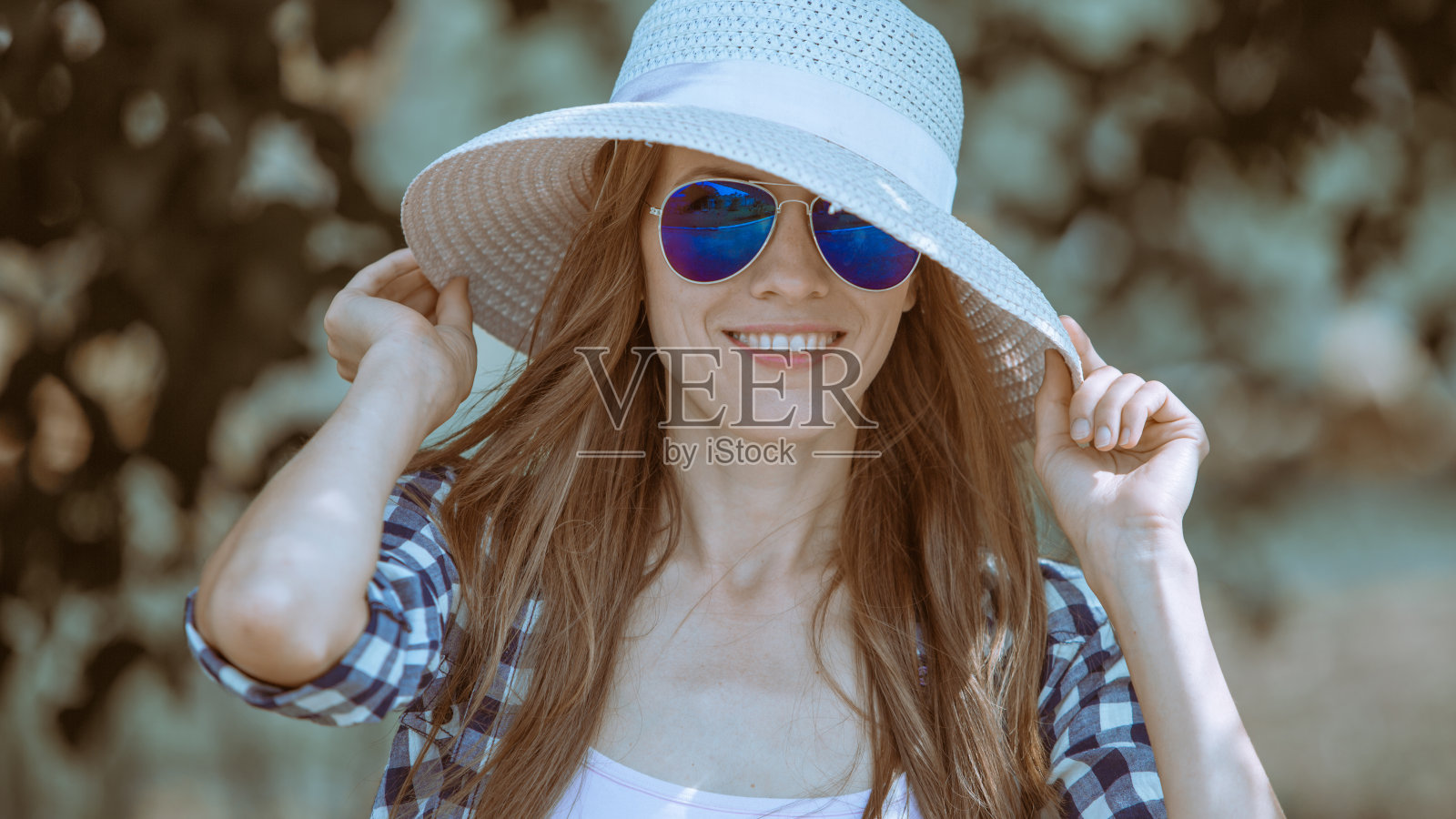 戴着墨镜和帽子的漂亮女人照片摄影图片