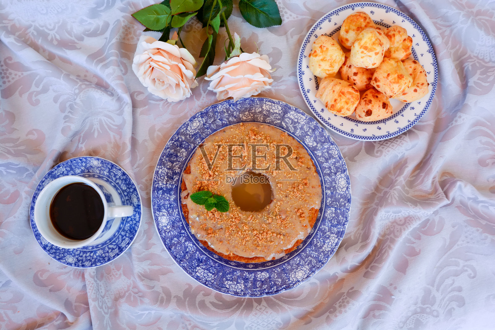 美味健康的早餐桌上有蛋糕，奶酪面包，麦片，咖啡，格子餐巾和木制的乡村餐桌照片摄影图片