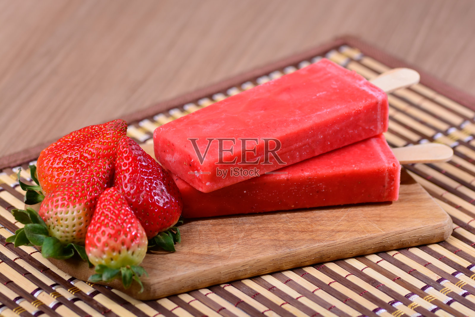 草莓冰棒，雪糕，木桌上的墨西哥风格冰棒，Paleta Mexican照片摄影图片