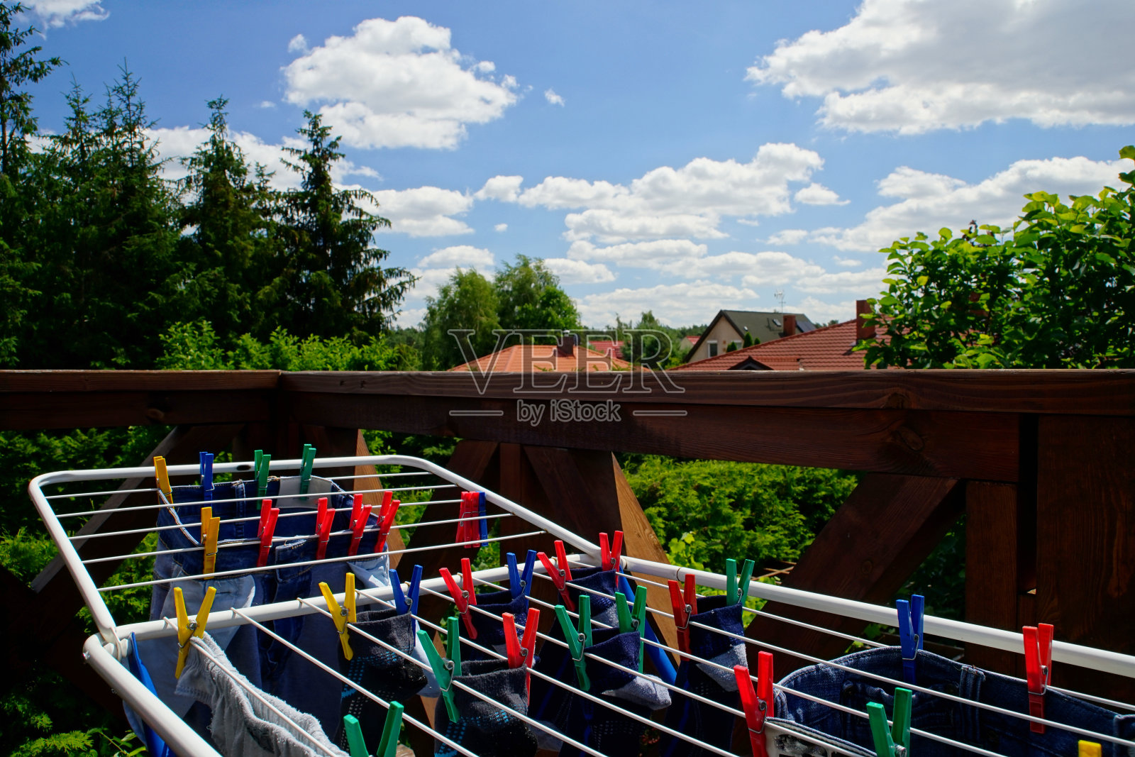 烘干机和彩色衣夹，阳台上的衣服在一个晴朗的日子照片摄影图片