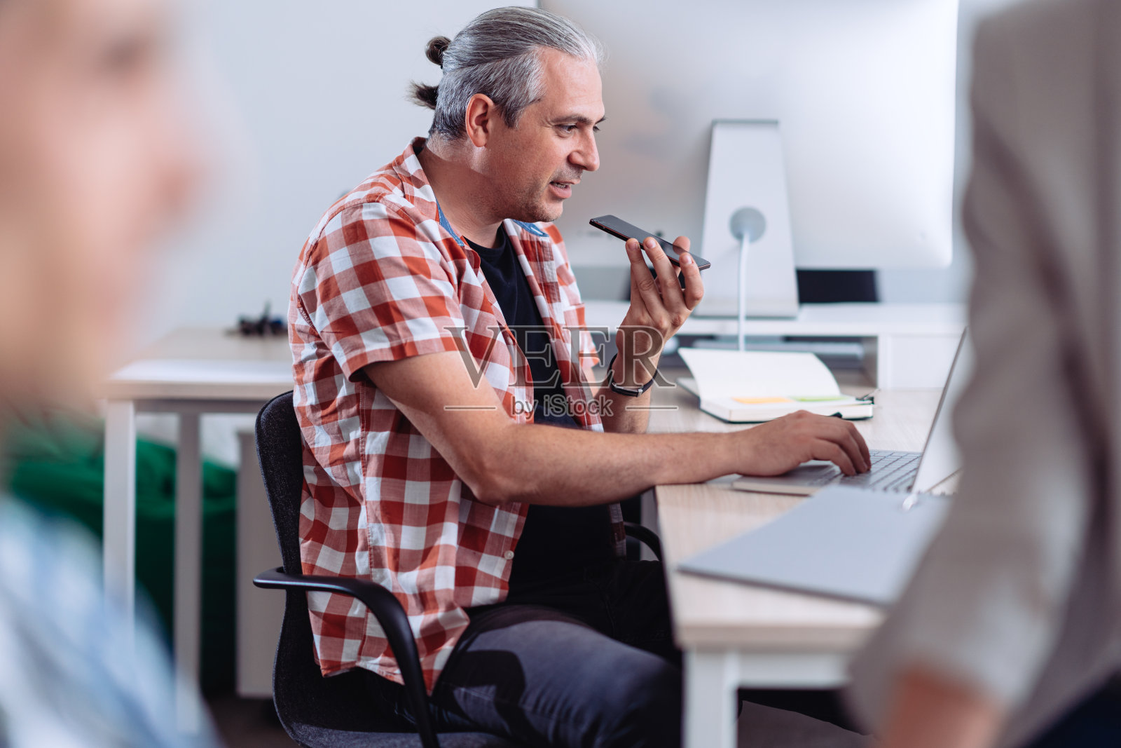 商人在办公室里用扬声器讲电话照片摄影图片