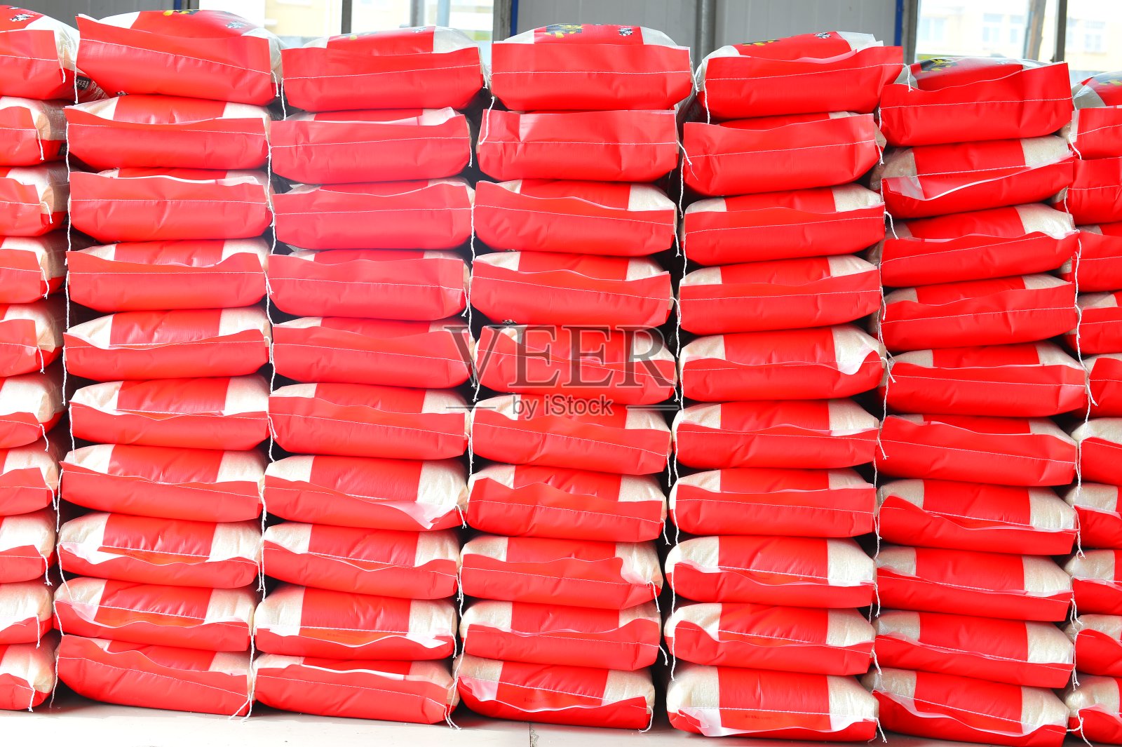 大仓库里有许多排装着货物的白色塑料袋照片摄影图片