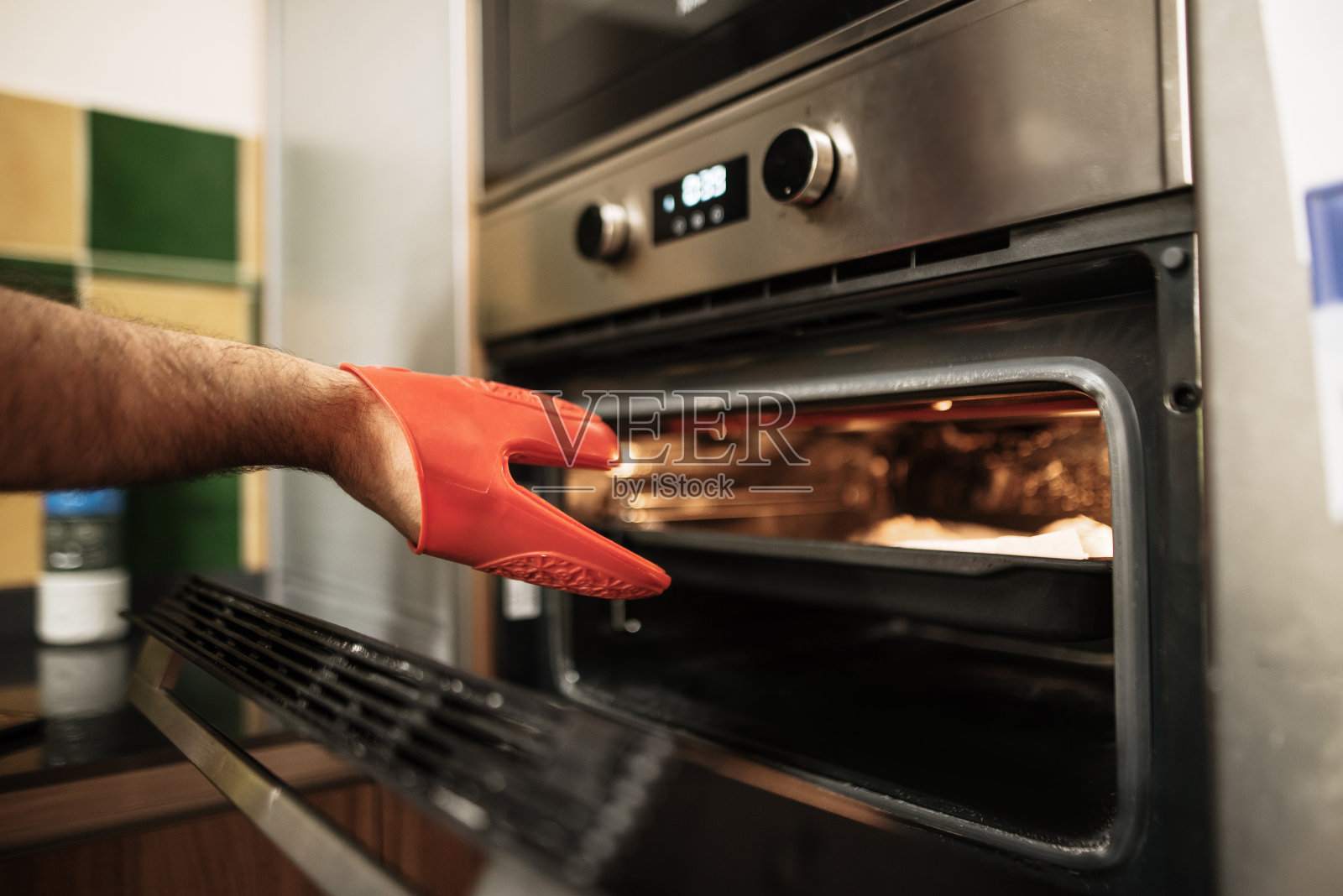 拿出一个烤箱托盘和塑料手套照片摄影图片