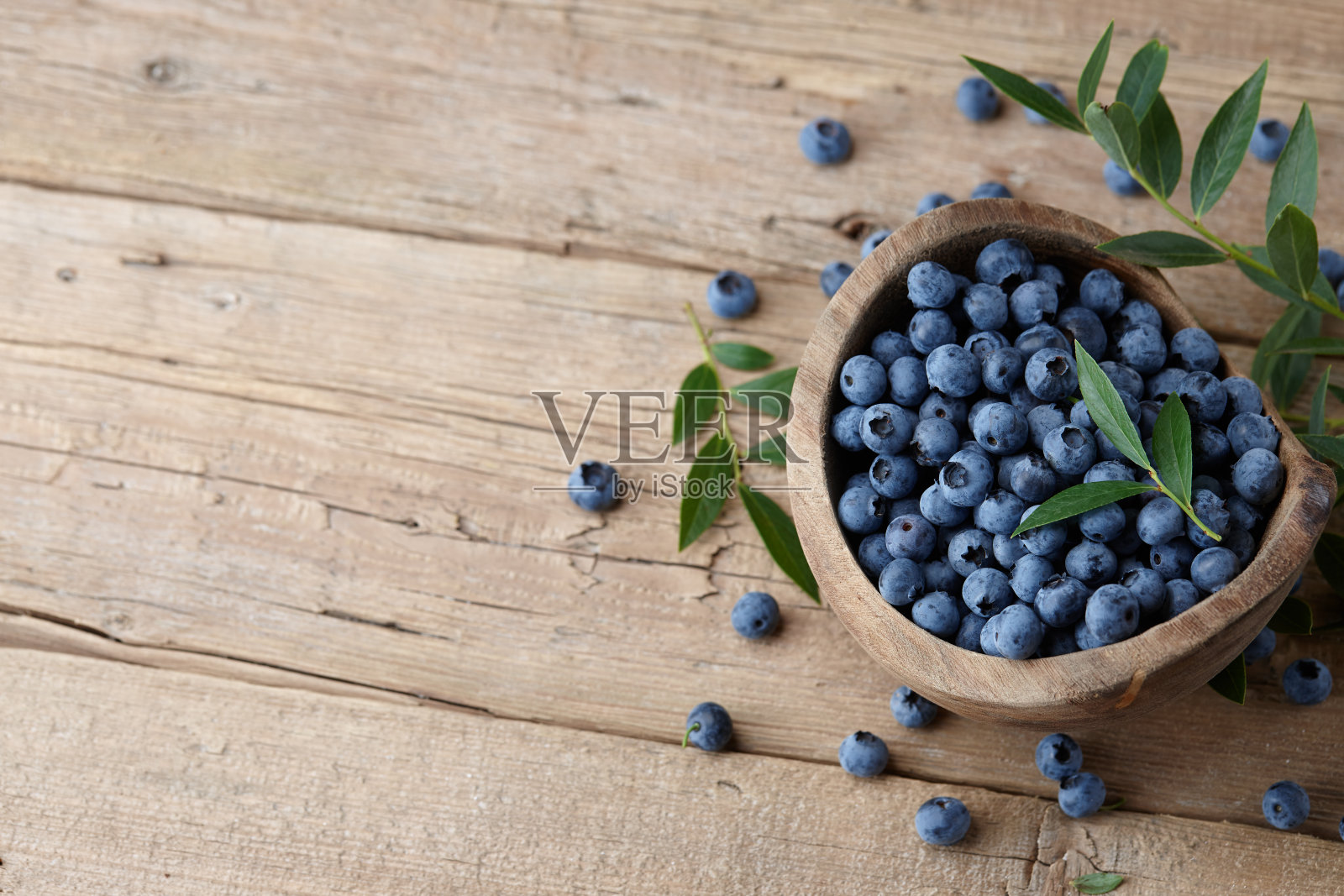 新鲜的蓝莓放在木碗里照片摄影图片