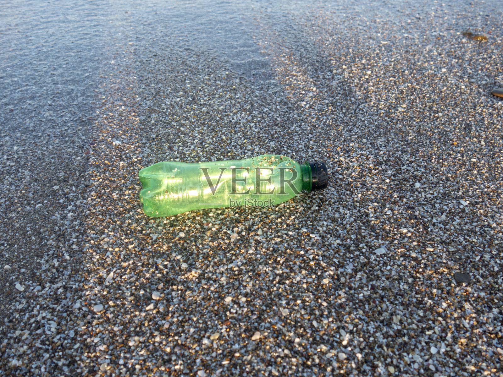 塑料水瓶被扔在沙滩上照片摄影图片