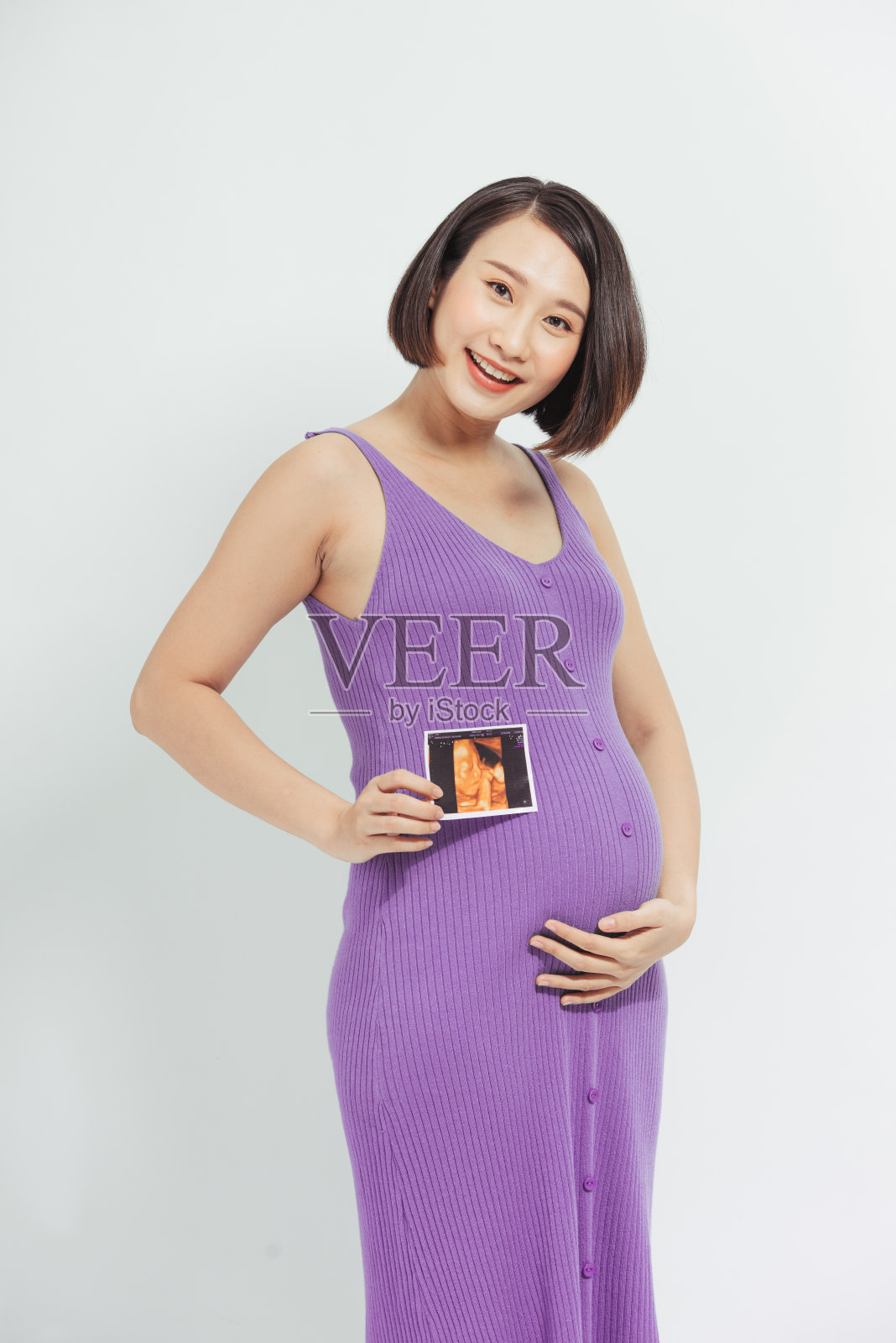 一名孕妇展示她未来宝宝的超声波照片。照片摄影图片