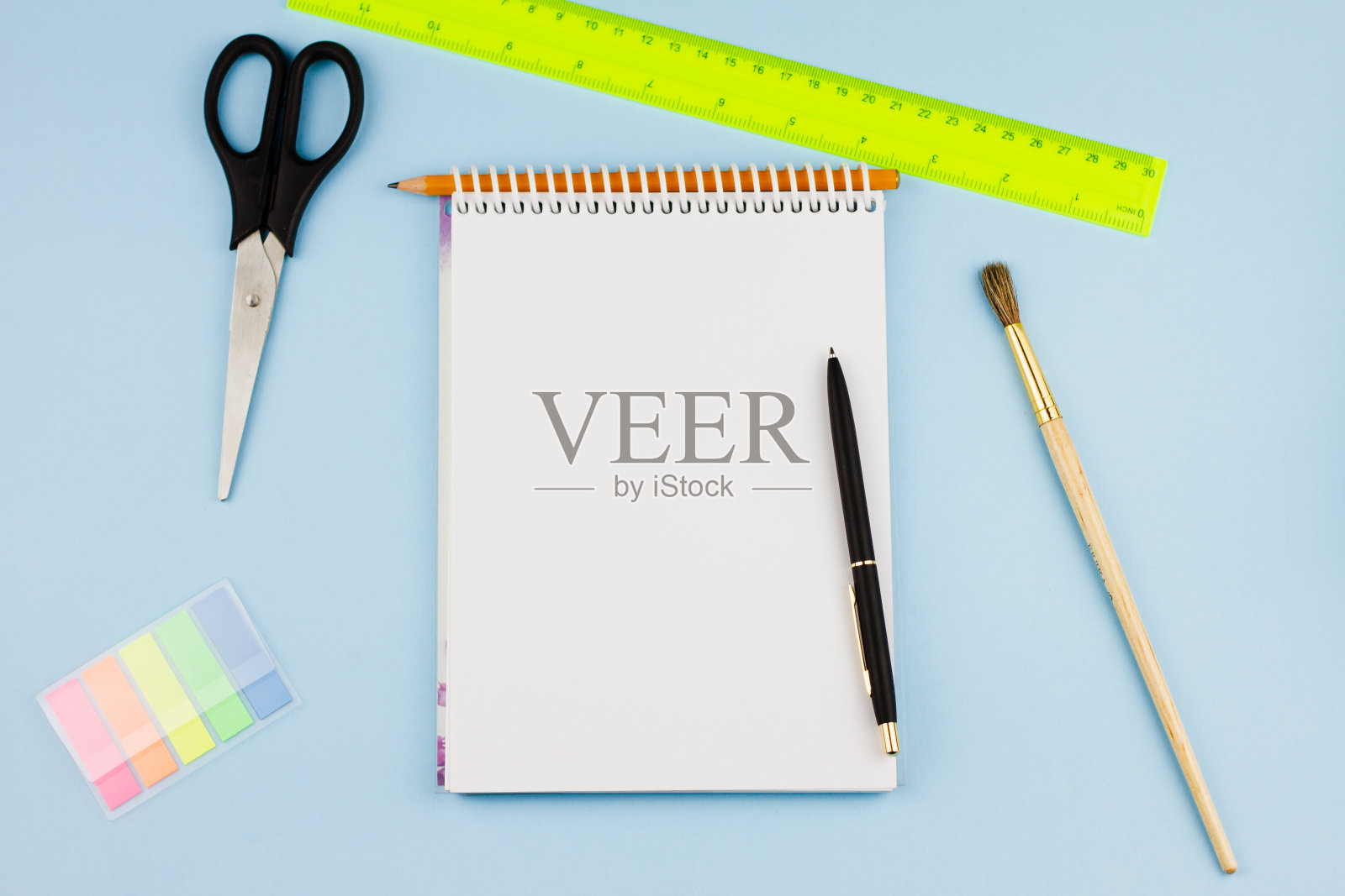 浅蓝色背景上的办公用品。照片摄影图片