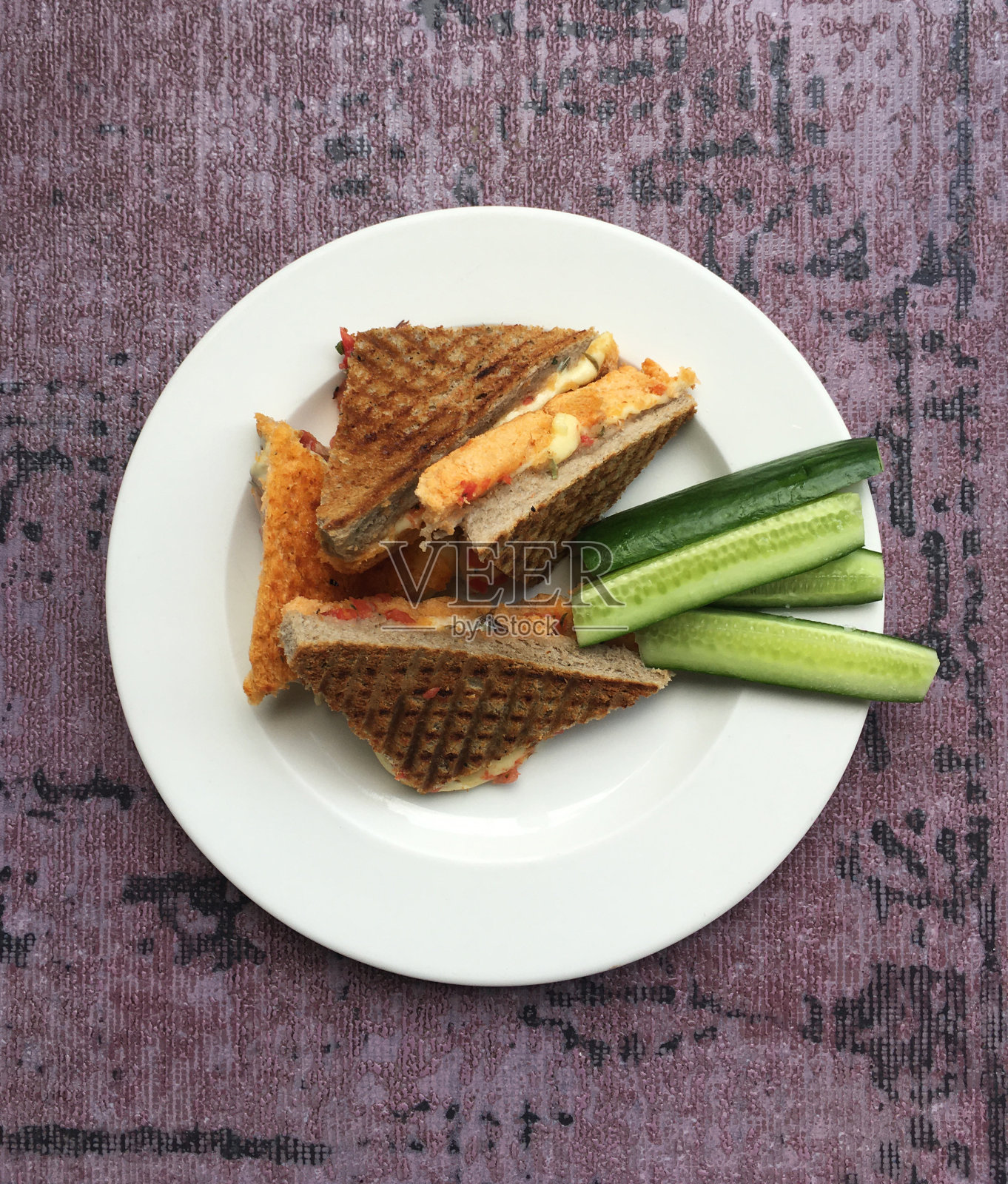 白色盘子上的热奶酪三明治和黄瓜照片摄影图片