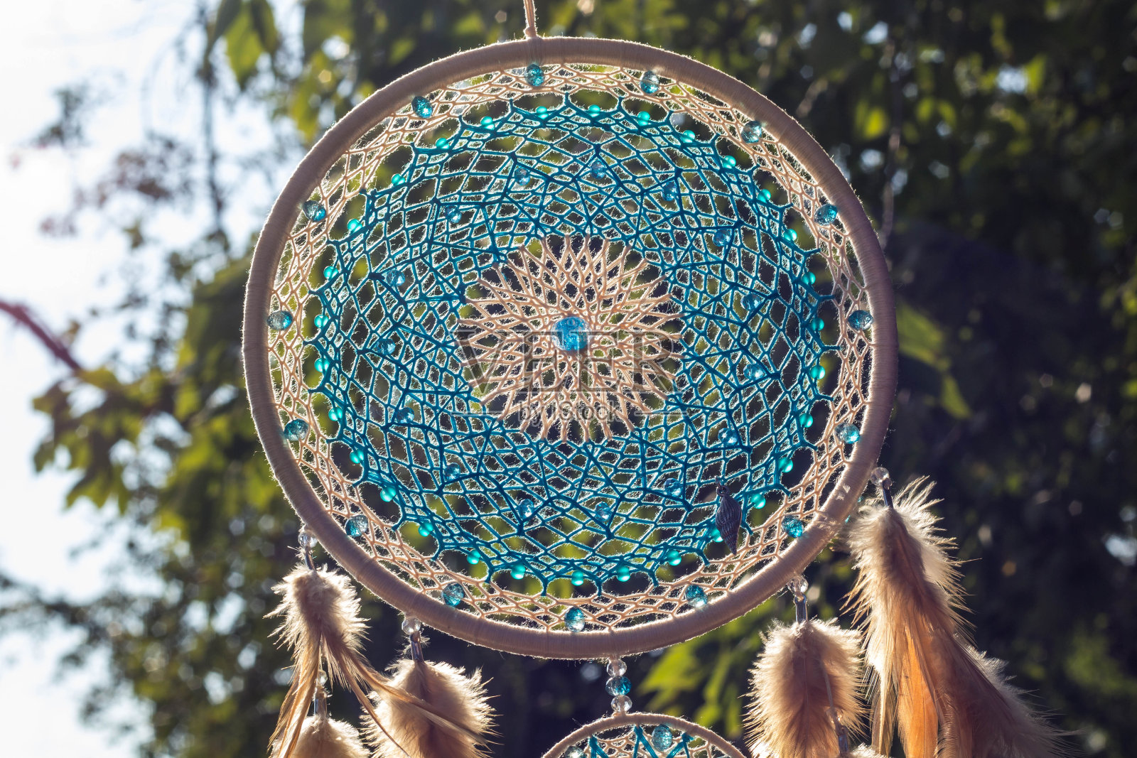 手工捕梦网，用羽毛、线和珠子绳挂照片摄影图片