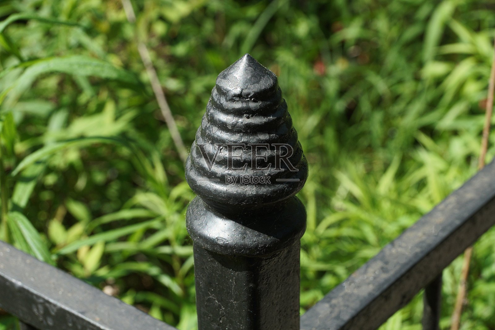 黑铁装饰篱笆的一部分，有一个尖锐的细节照片摄影图片