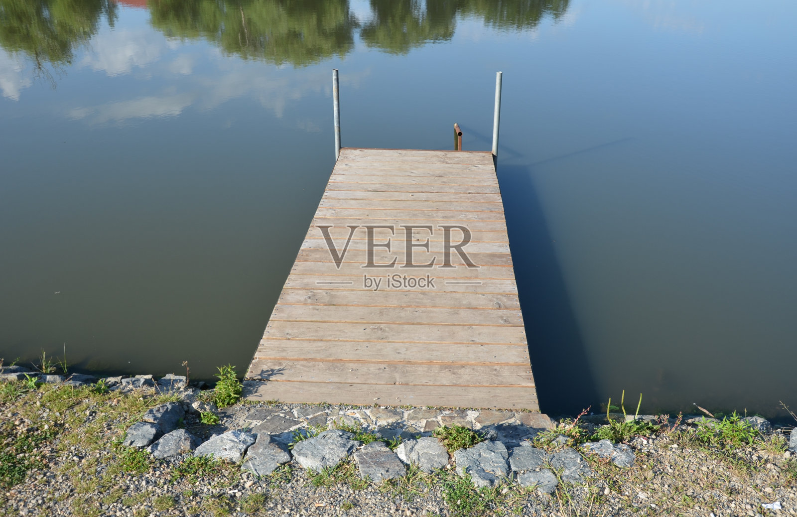 河边池塘上方有一个木制的小钓鱼码头，用于舒适的钓鱼或系泊船只、驳船，可以用来支撑渔民的钓竿照片摄影图片