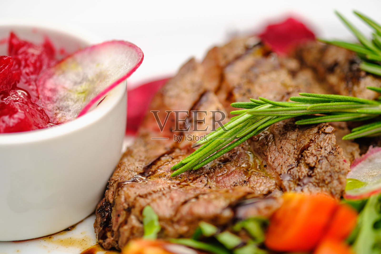 烤马索配蔬菜和迷迭香放在白盘子上。照片摄影图片