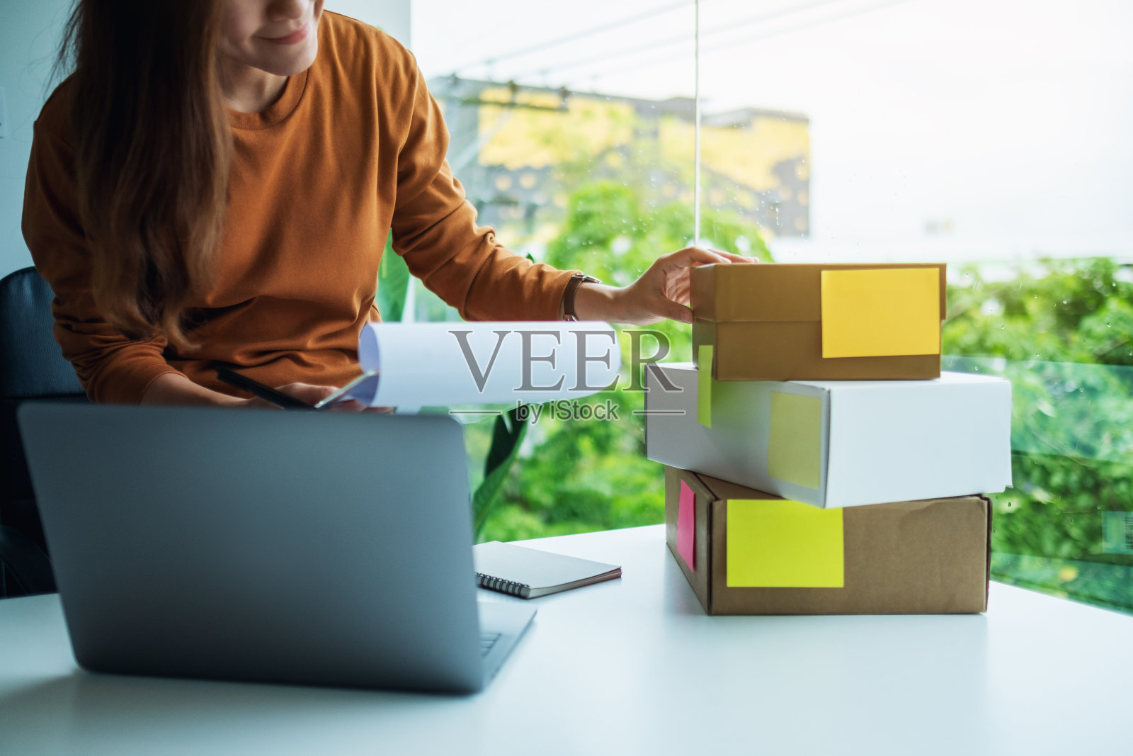 年轻女企业家在笔记本电脑上查看客户的订单照片摄影图片