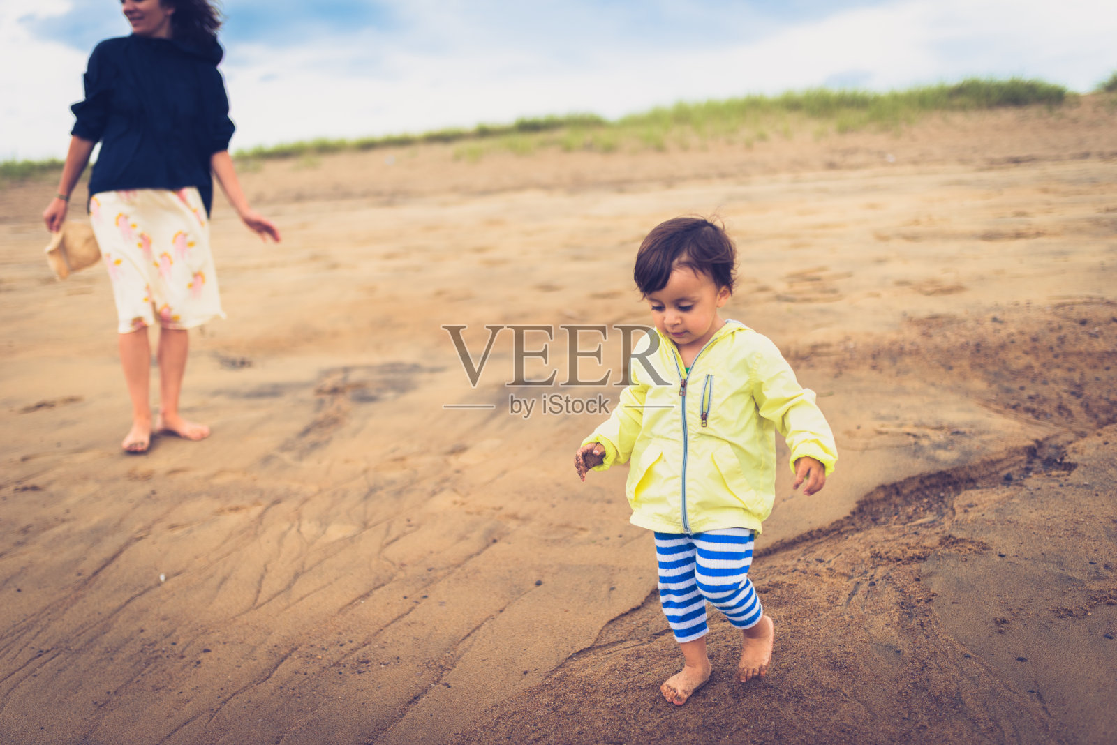 可爱的小女孩和她的妈妈在沙滩上玩照片摄影图片