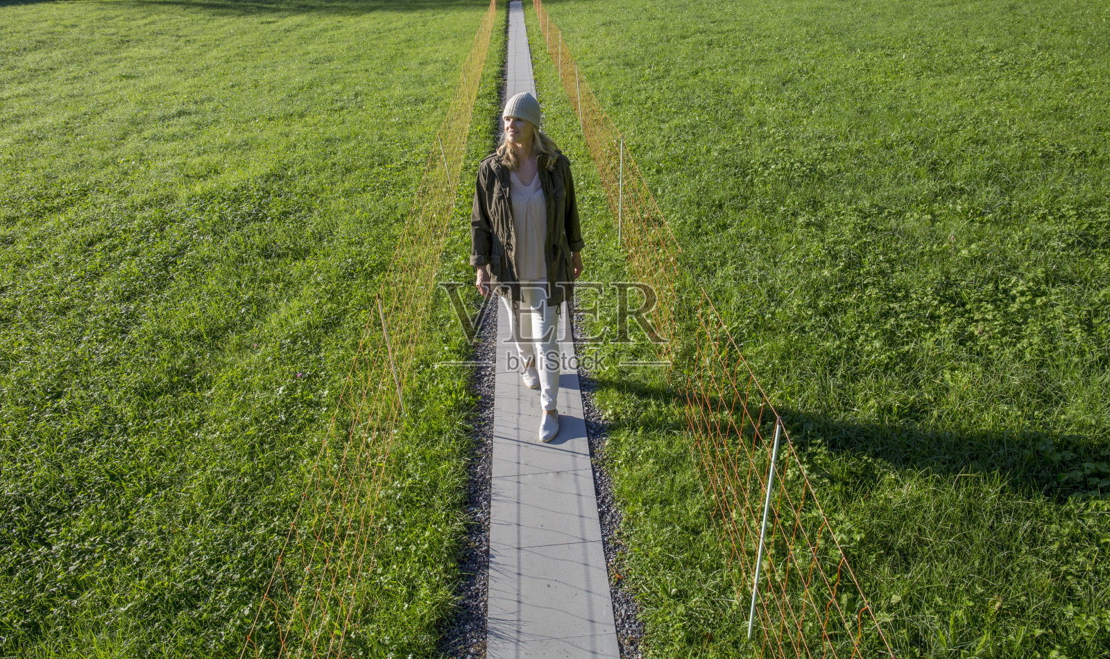 一个女人走在瑞士阿尔卑斯山的乡间小路上照片摄影图片