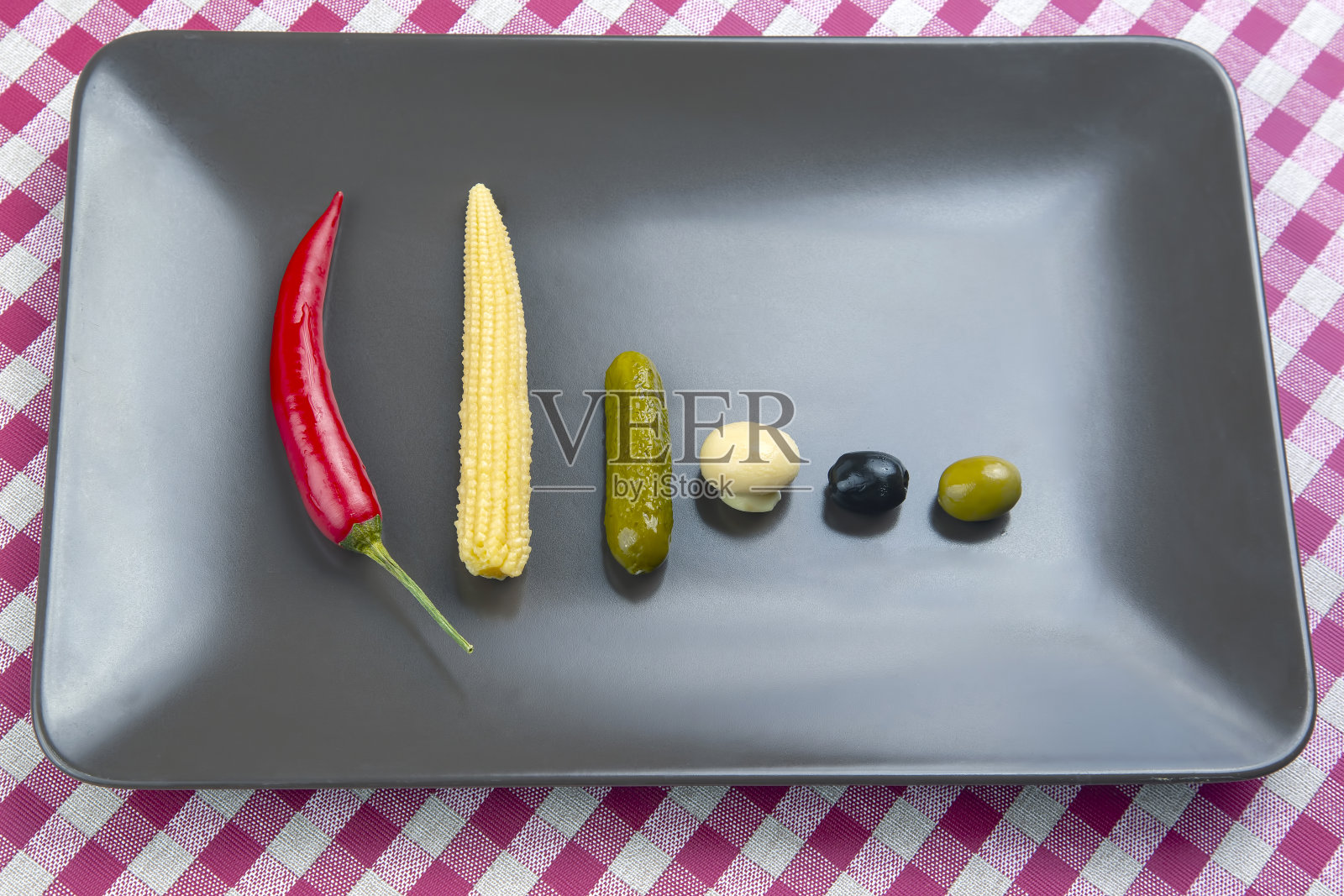 橄榄，腌黄瓜，胡椒，蘑菇和玉米沙拉在一个盘子里。食物和蔬菜。饮食与减肥照片摄影图片