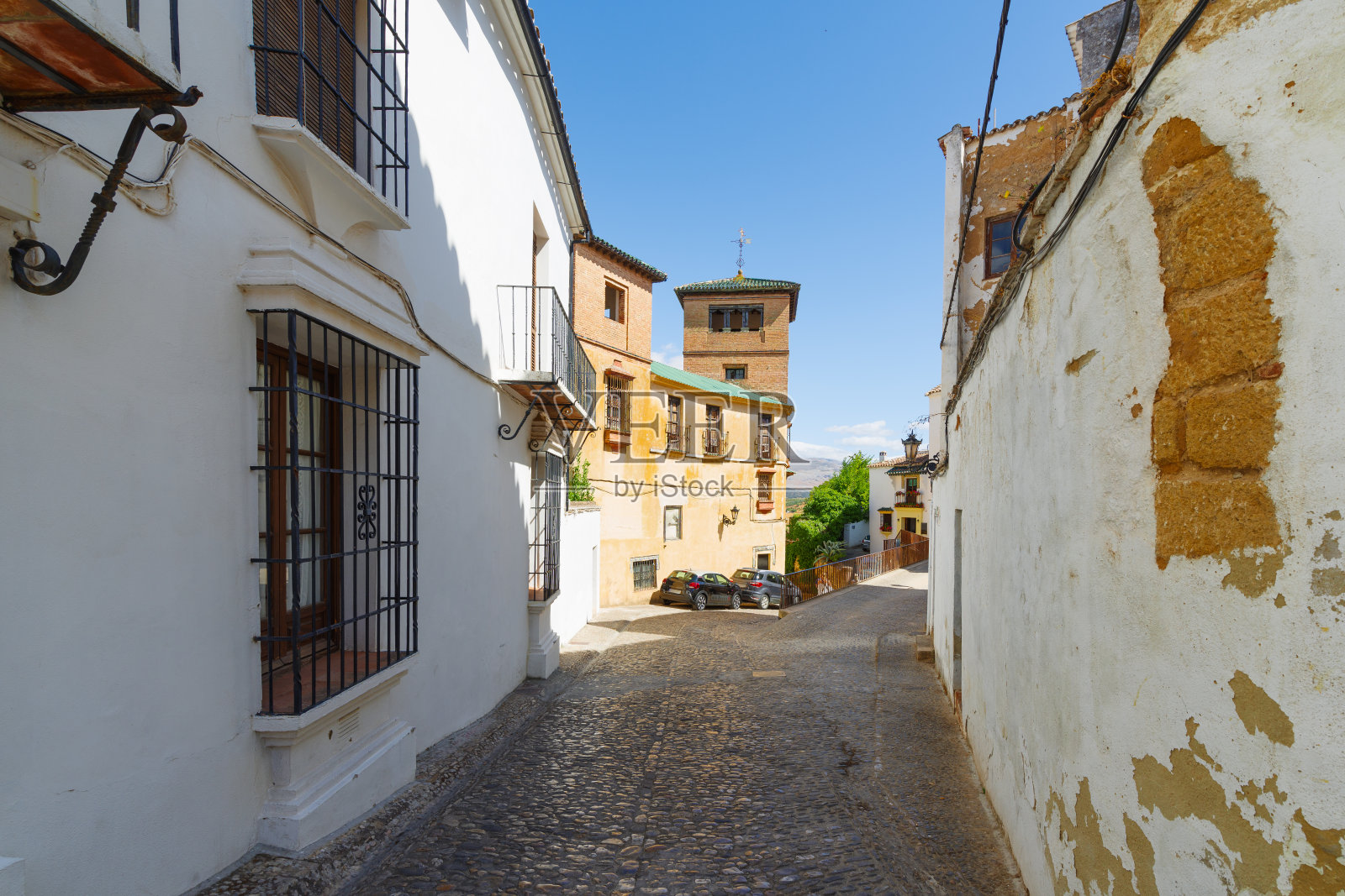 在古老的欧洲城市里，一条狭窄的街道，有白色的房子和丰富的绿色植物照片摄影图片