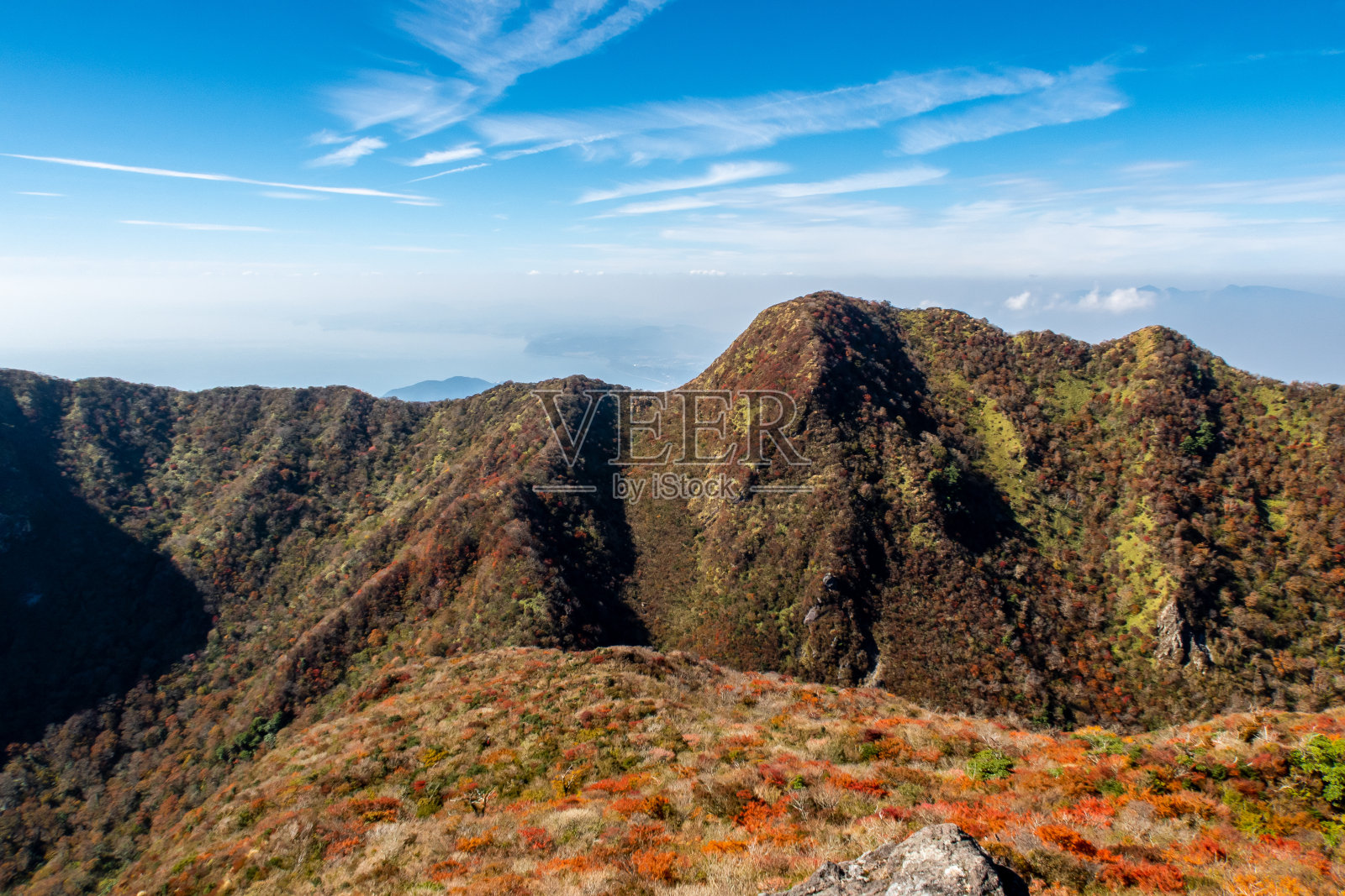 11月阳光明媚的日本，云仙天草国家公园的山中有水晶般湛蓝的天空，红、黄、橙三色的秋树。照片摄影图片