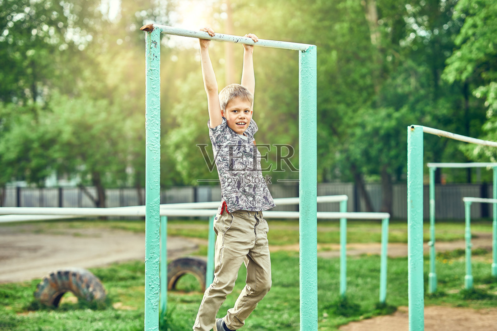 强壮的孩子在操场上做引体向上照片摄影图片