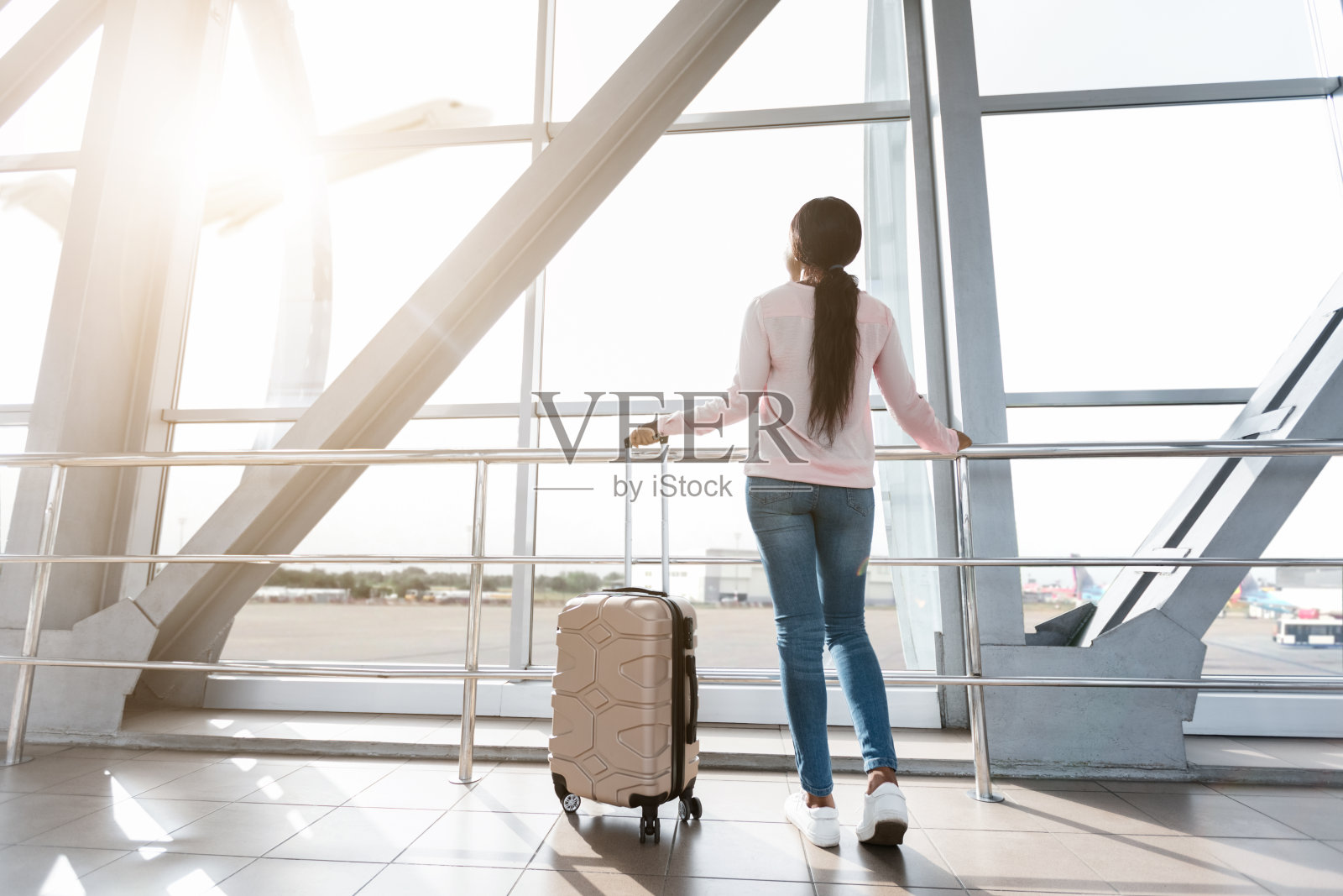 等待航班。黑人妇女在机场看窗户的后视图照片摄影图片