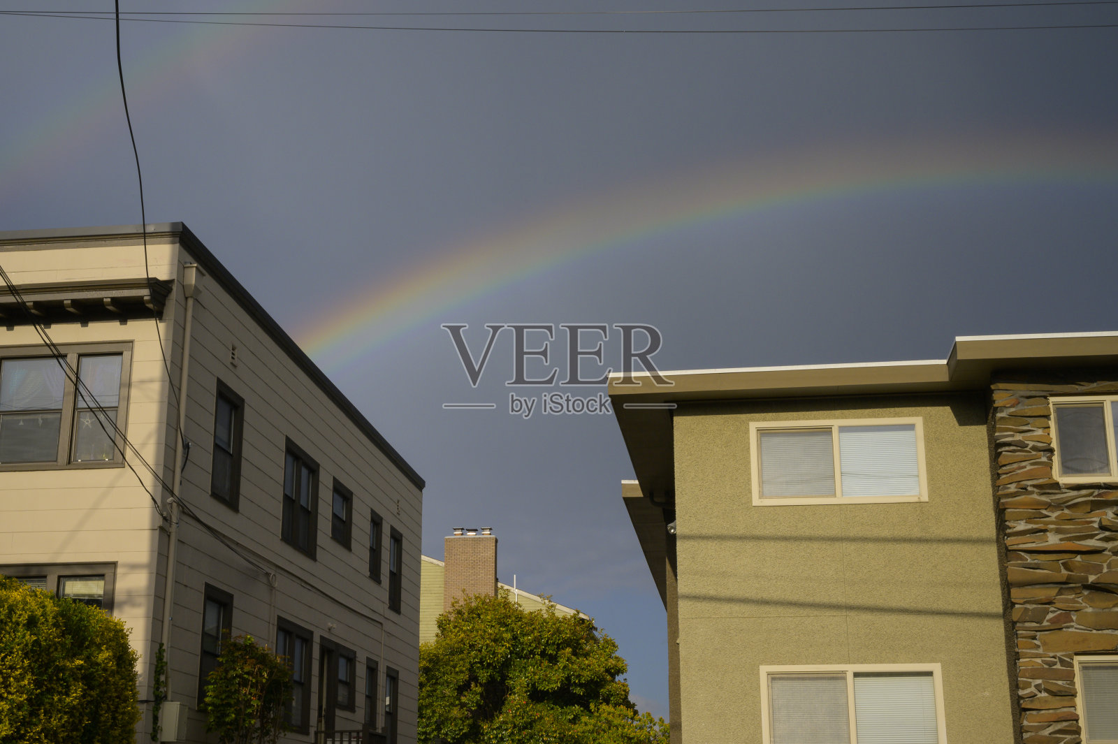 彩虹在公寓楼和城市的蓝天照片摄影图片