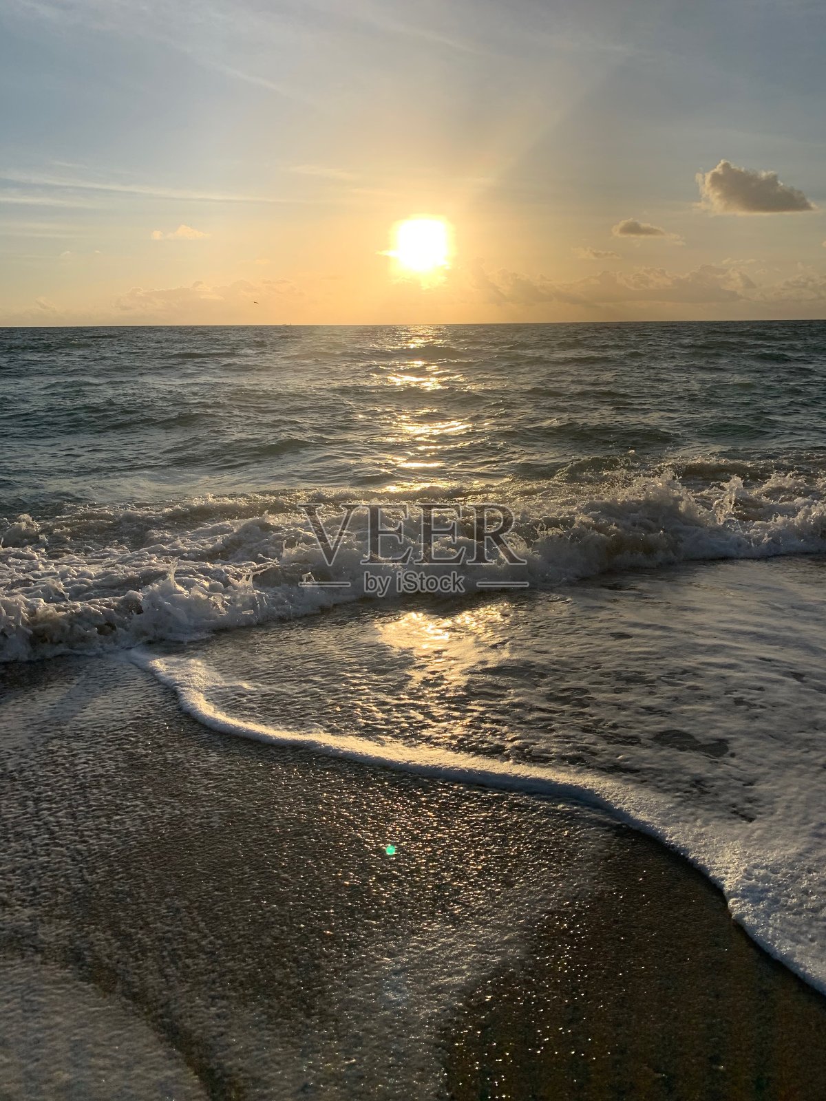 明亮的日出下，海洋的海岸线波涛汹涌照片摄影图片