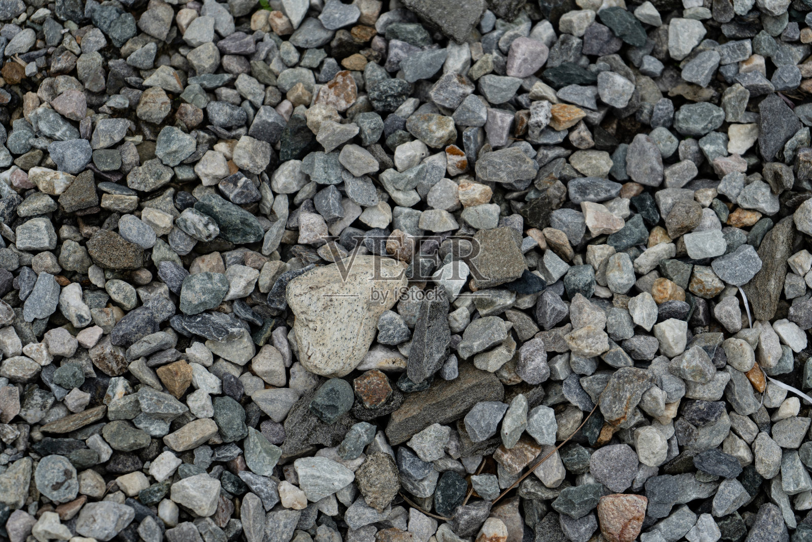 抽象设计由各种数量的鹅卵石散落在草坪上形成，鹅卵石的背景纹理。照片摄影图片