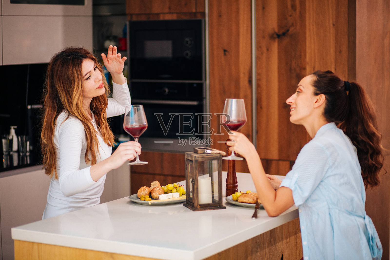 两个女人在家里享用开胃菜和酒的照片照片摄影图片