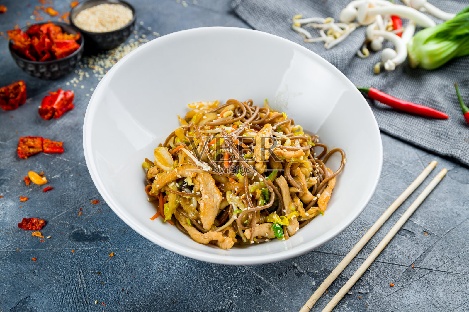 灰色的桌子上放着鸡肉炒面照片摄影图片