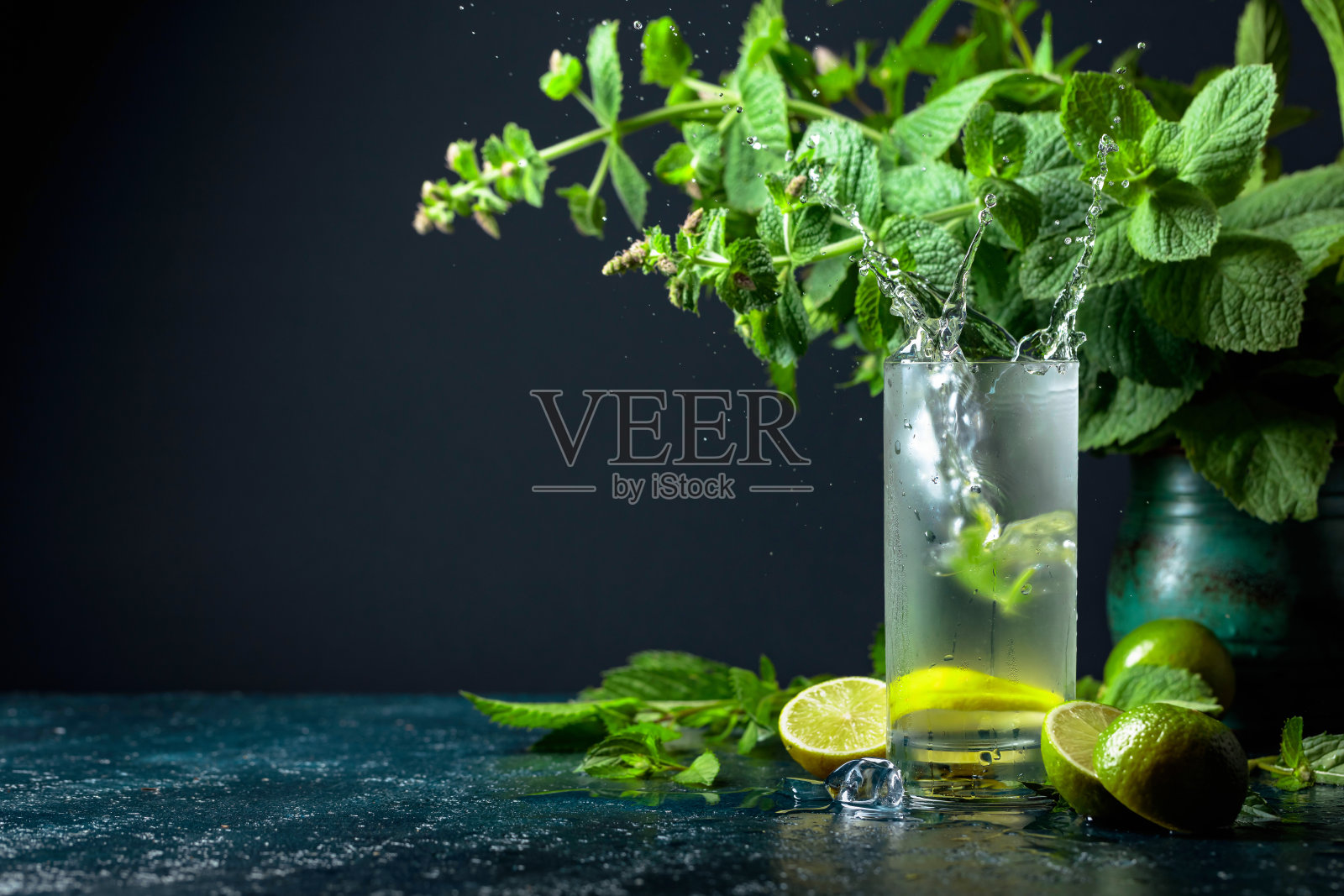 碎冰和莫吉托一起落在玻璃杯里。照片摄影图片