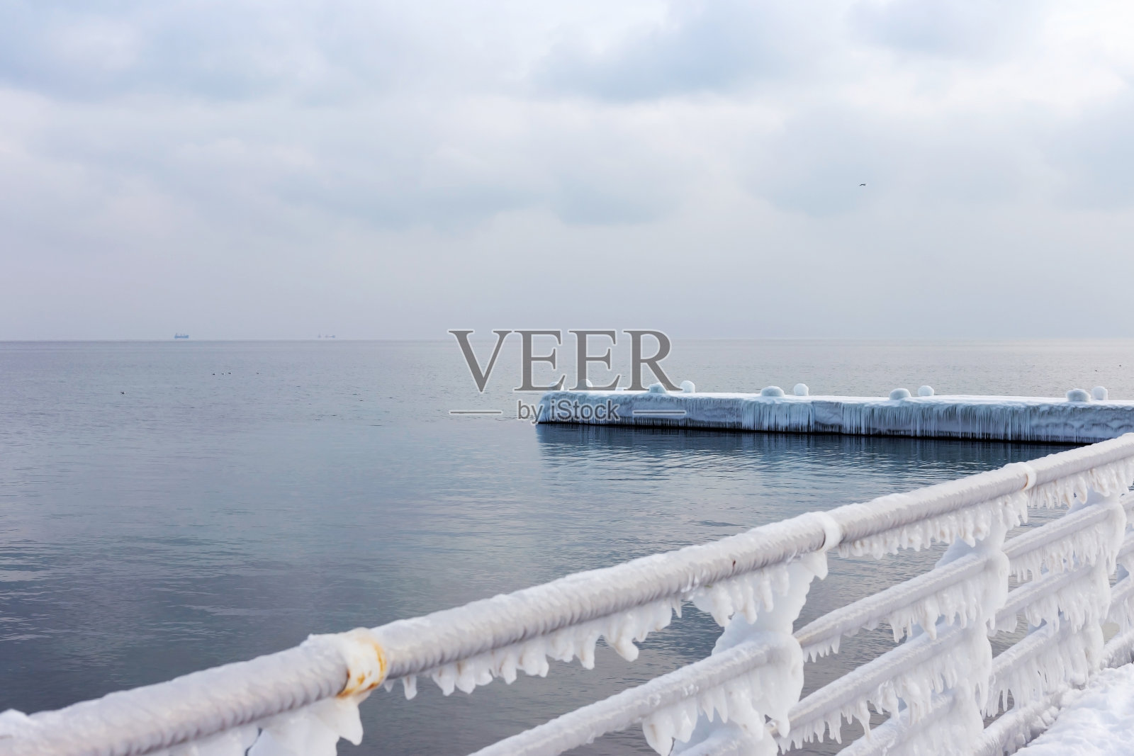 冰雪在海上漫步。在一场霜冻的强暴风雪后，给海滨长廊结上了冰。照片摄影图片