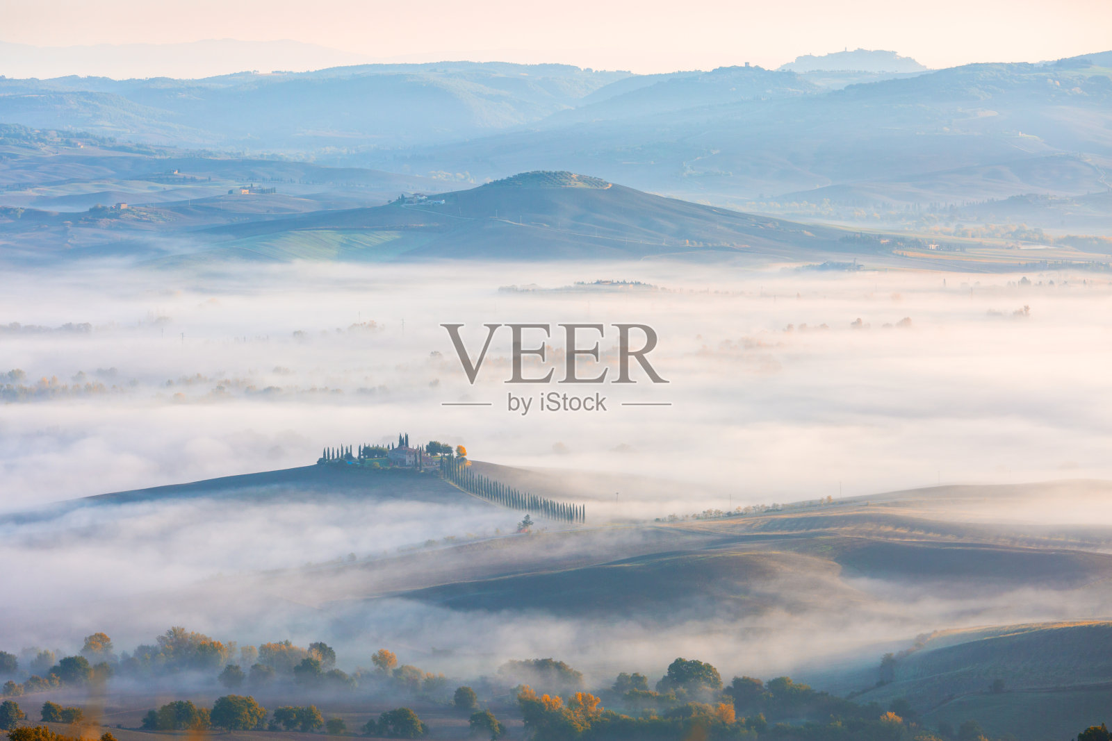 在意大利托斯卡纳锡耶纳省的瓦尔德奥西亚附近，托斯卡纳山谷被秋天的晨雾覆盖的典型景象照片摄影图片