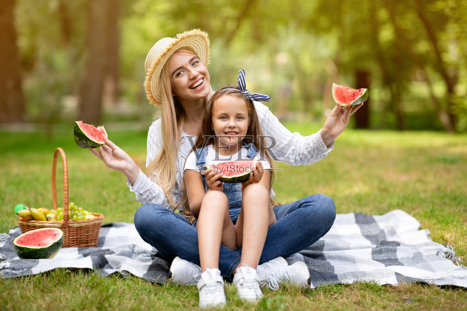 妈妈和女儿摆造型，西瓜坐在外面的格子图案上照片摄影图片