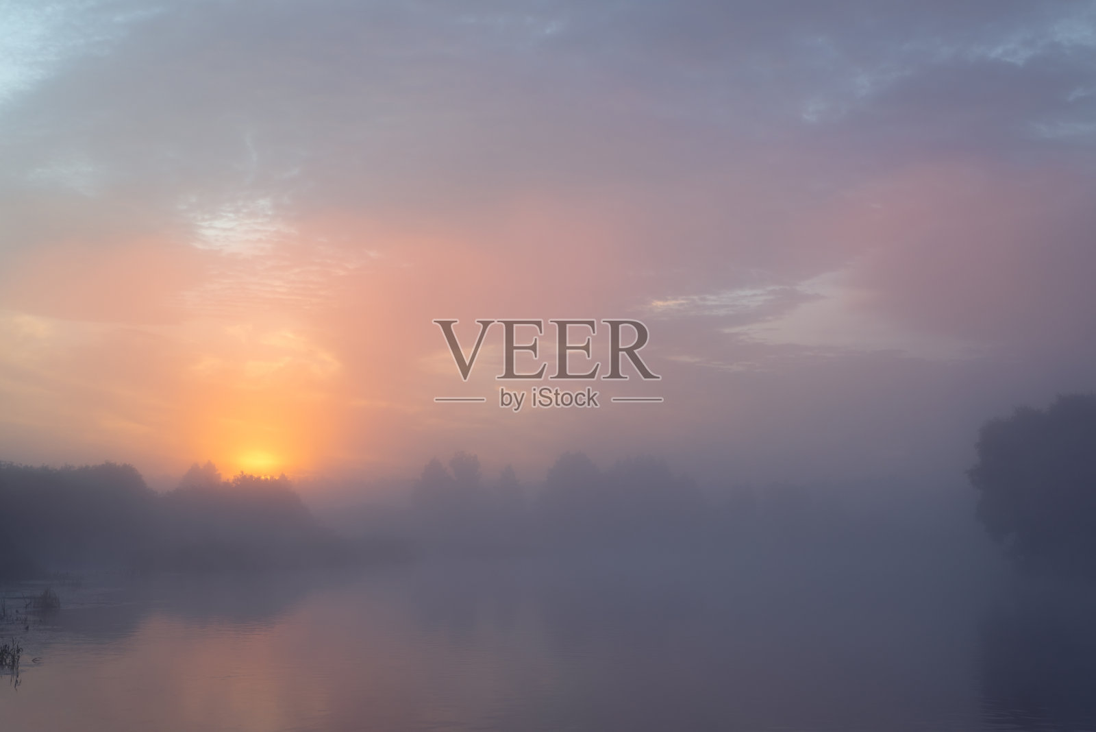 日出时分宁静的晨光。河上有浓雾。黎明照亮了天空，使云变得五颜六色。照片摄影图片